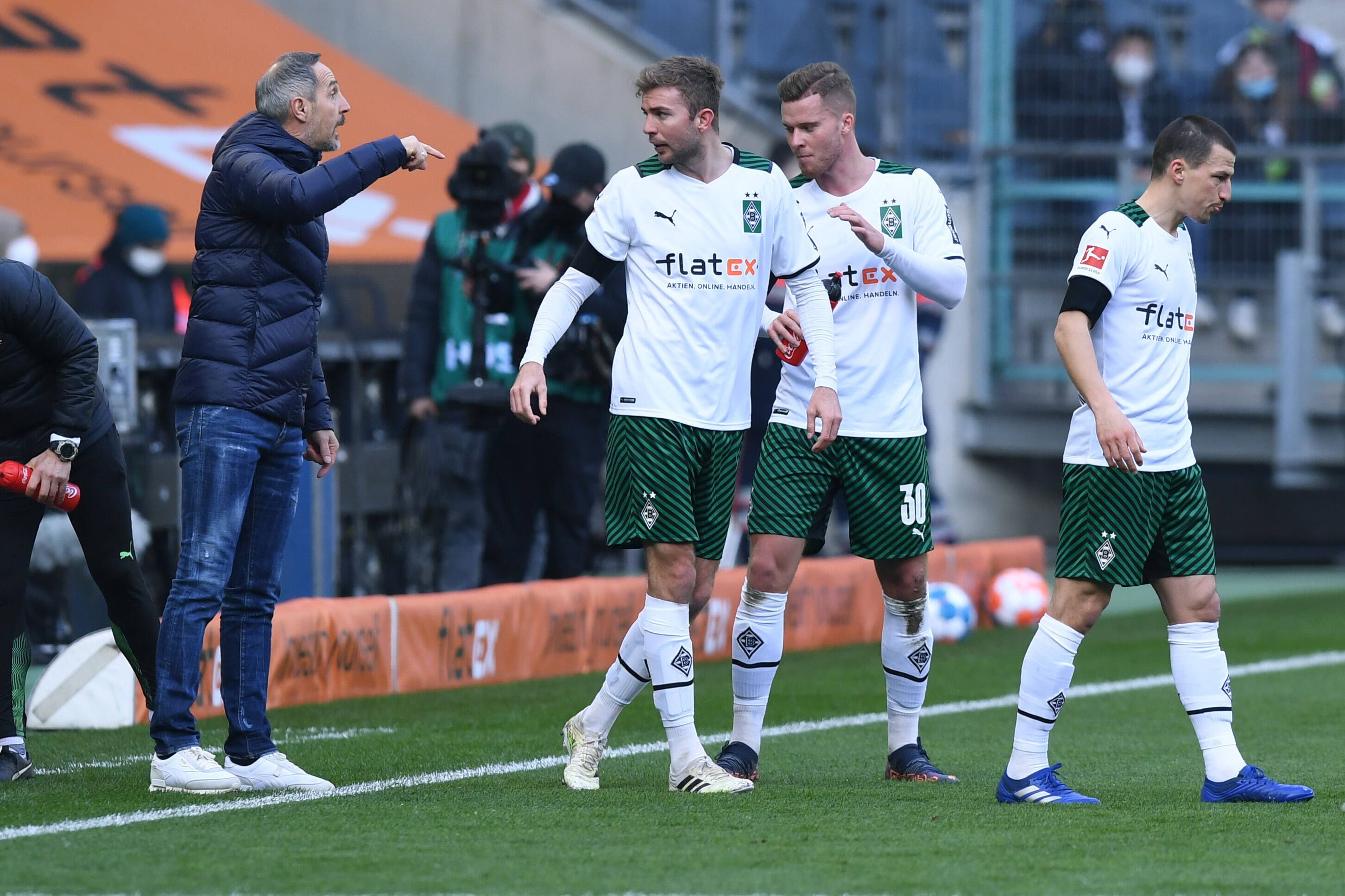Adi Hütter (l.) gibt als Trainer von Borussia Mönchengladbach Anweisungen am Spielfeldrand an Christoph Kramer, Nico Elvedi und Stefan Lainer. Das Foto stammt vom Bundesliga-Heimspiel gegen den VfL Wolfsburg am 26. Februar 2022.