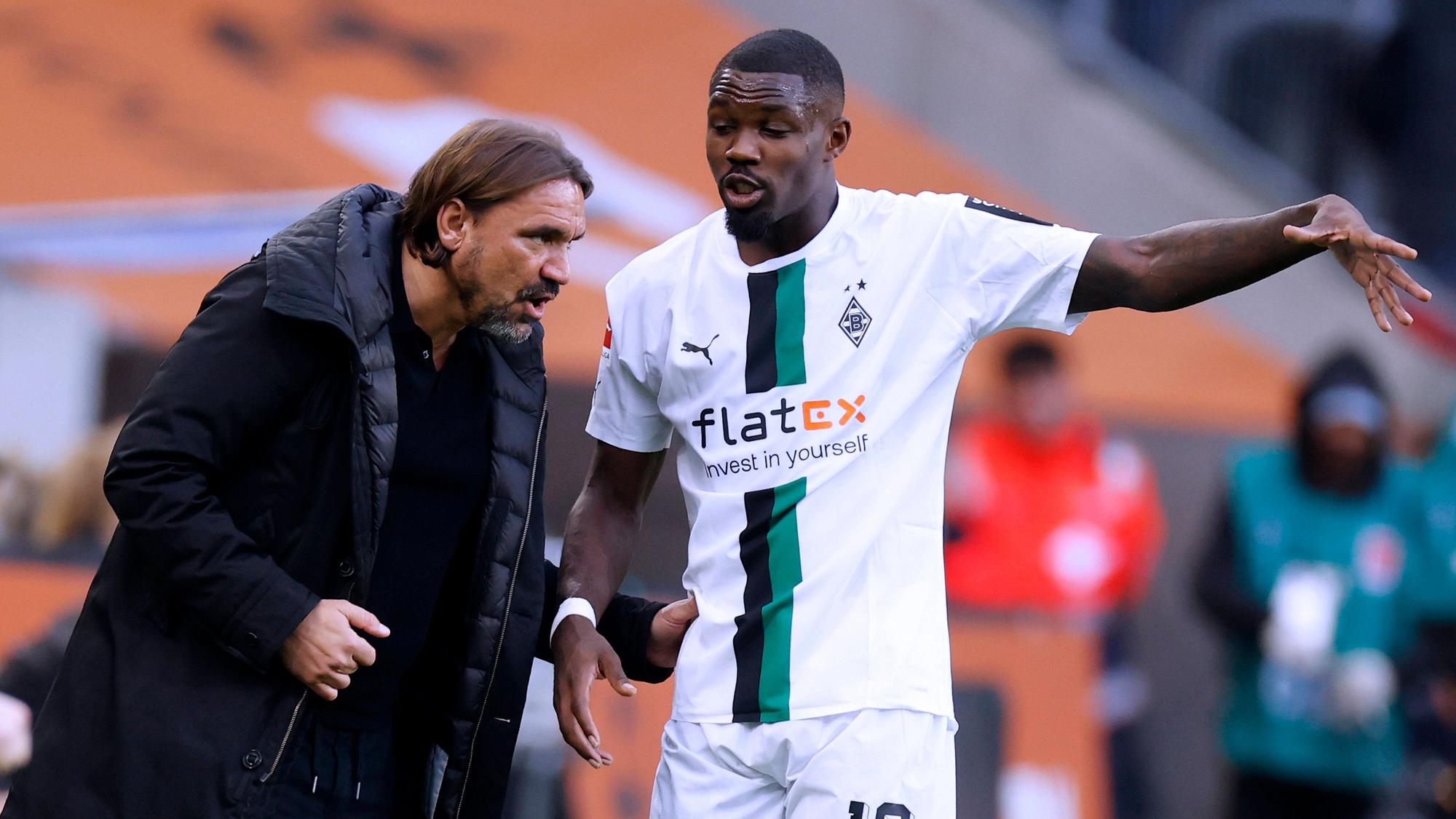 Daniel Farke (l.) und Marcus Thuram unterhalten sich am 17. September 2022 an der Seitenauslinie während eines Spiels von Borussia Mönchengladbach im Borussia-Park.