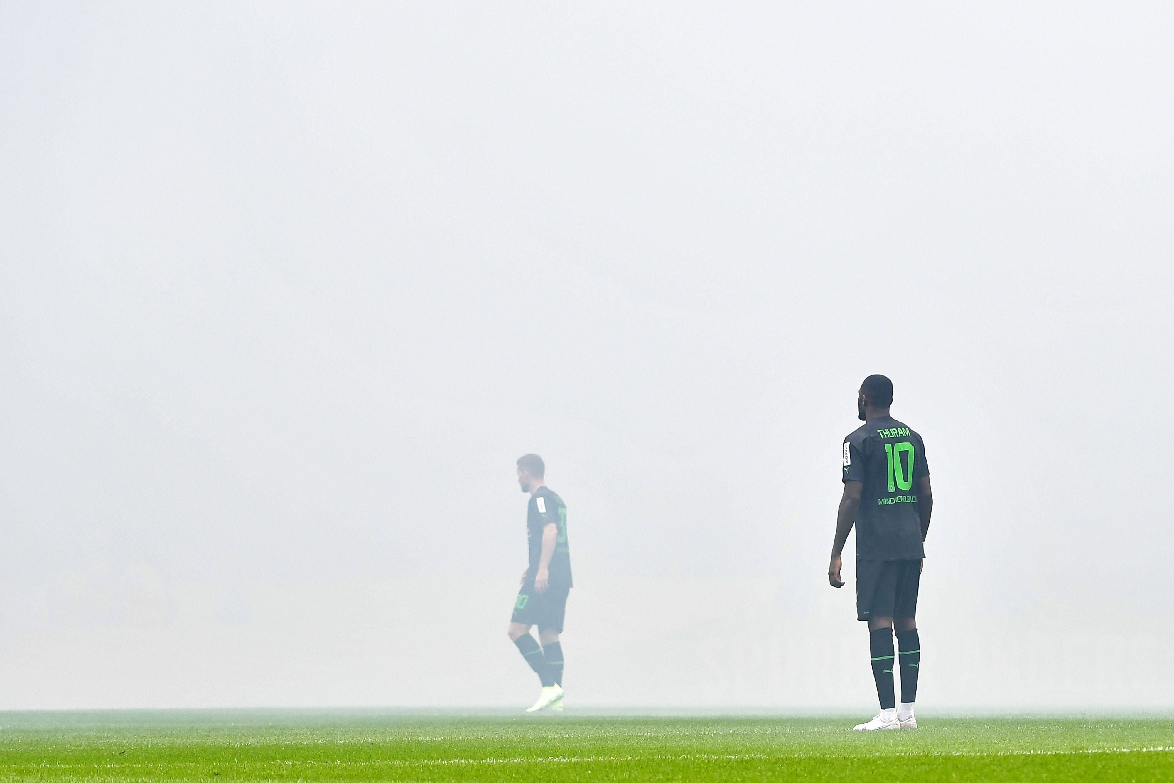 Nico Elvedi (l.) und Marcus Thuram stehen im Pyro-Nebel im Stadion des 1. FC Köln beim Derby am 2. April 2023.