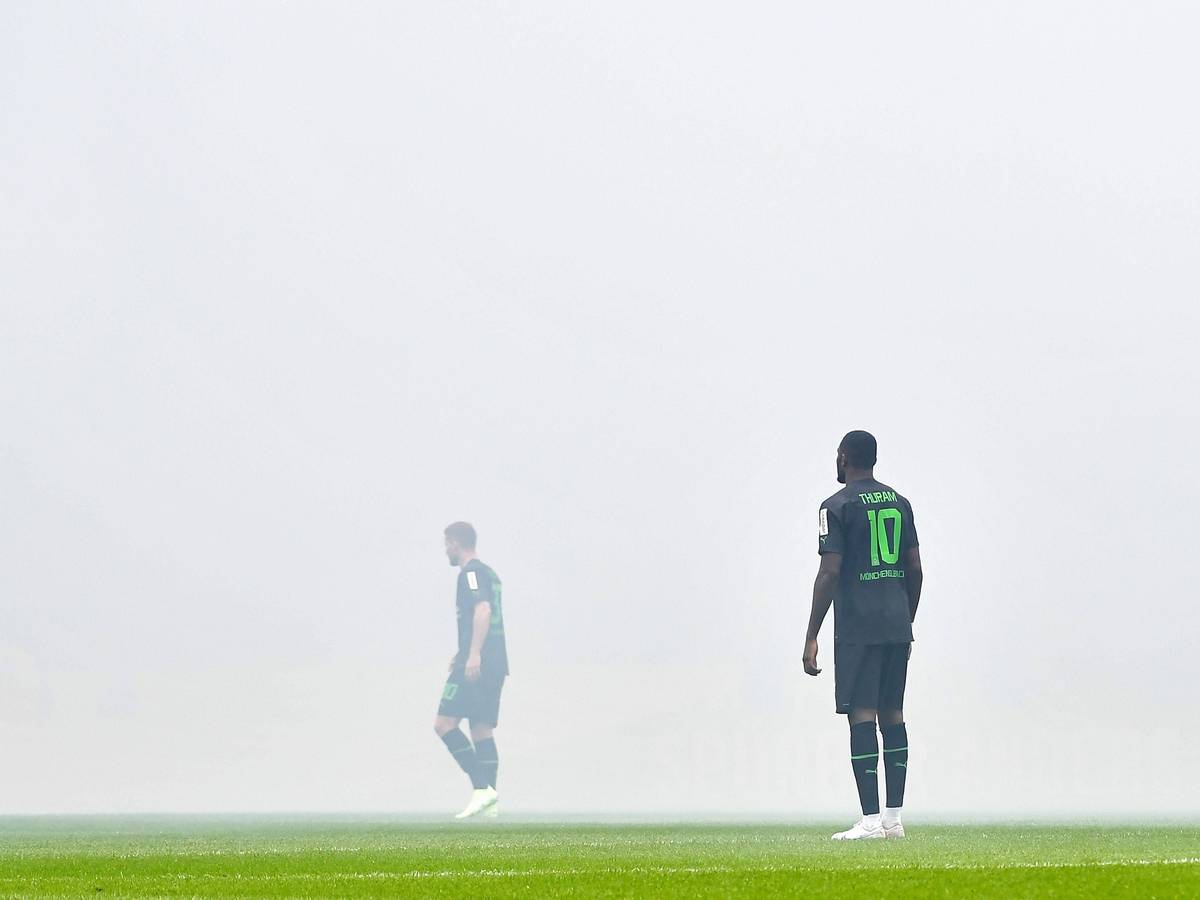 Nico Elvedi (l.) und Marcus Thuram stehen im Pyro-Nebel im Stadion des 1. FC Köln beim Derby am 2. April 2023.