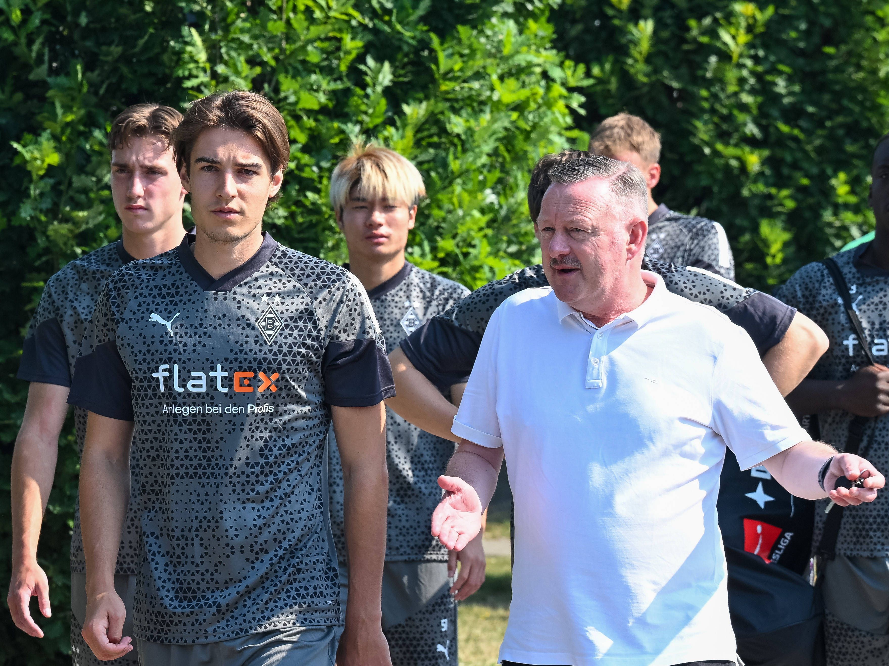 Florian Neuhaus (l.) und Roland Virkus unterhalten sich vor dem ersten Training von Borussia Mönchengladbach in der Saison 2023/24 am 9. Juli 2023.