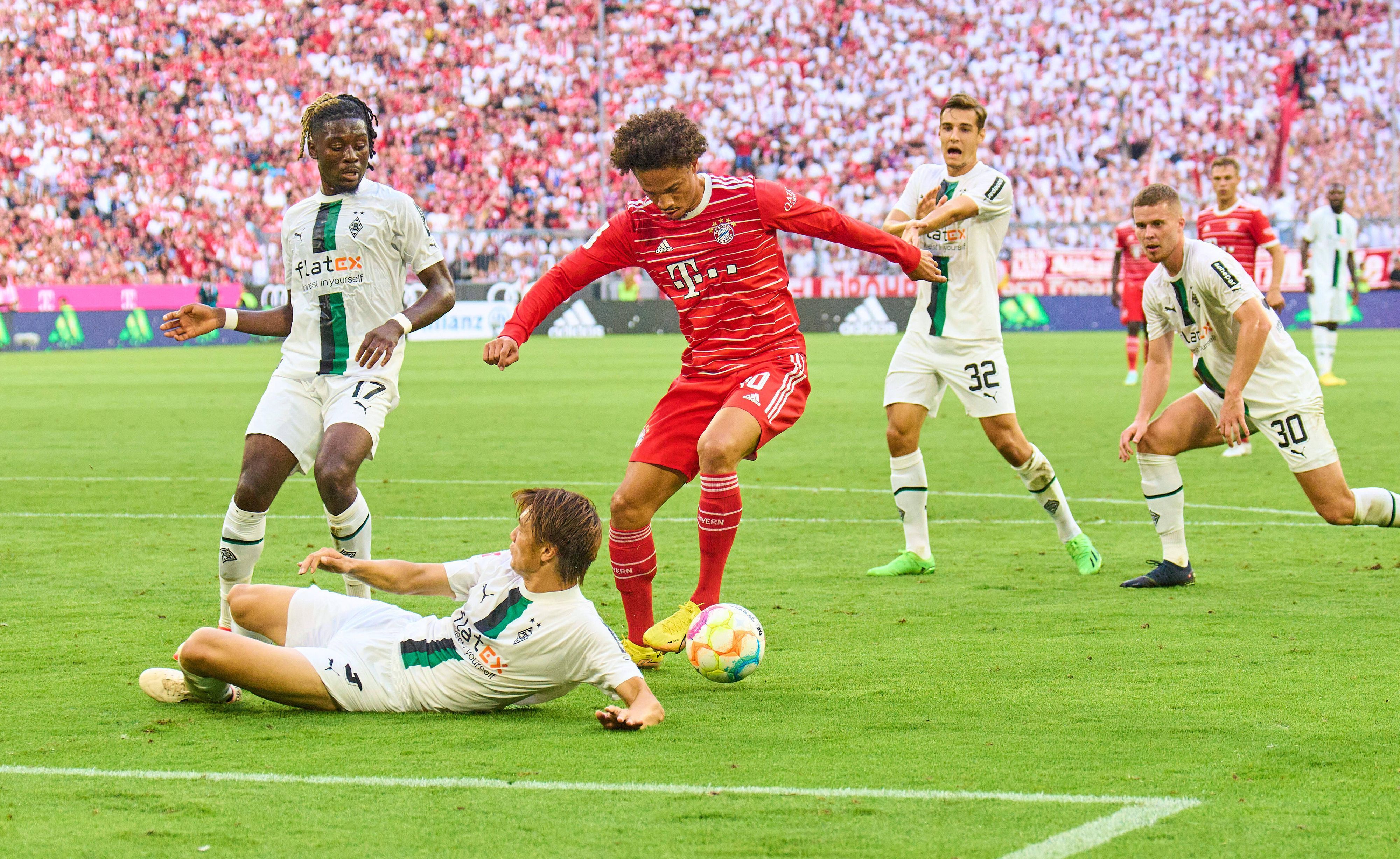 Leroy Sané von Bayern München will beim Bundesliga-Spiel gegen Borussia Mönchengladbach am 27. August 2022 schießen, wird aber von Ko Itakura (liegend) geblockt.