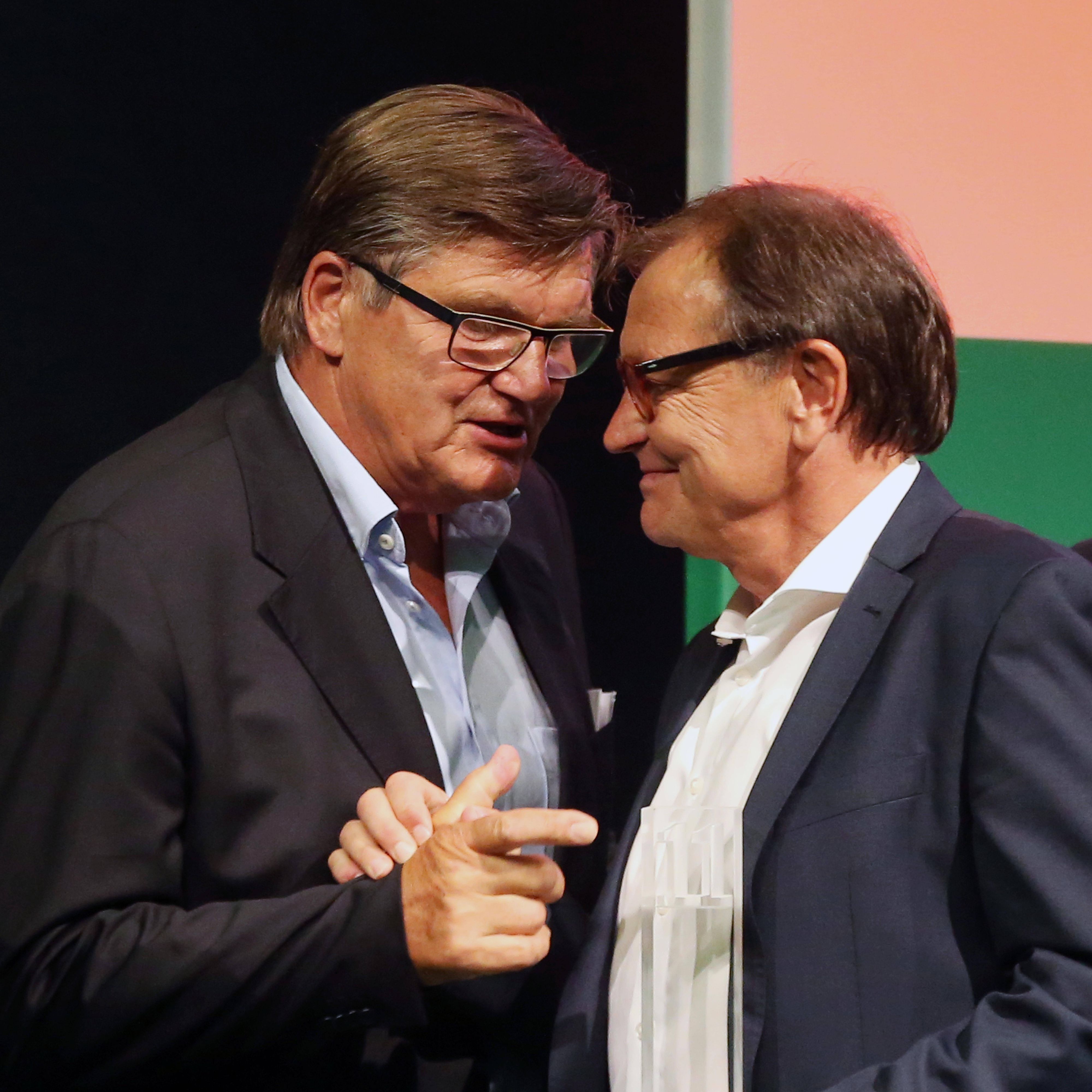 Hans Meyer (l.) und Ewald Lienen nehmen am 14. Juli 2017 an einer Veranstaltung teil und sprechen auf der Bühne miteinander.
