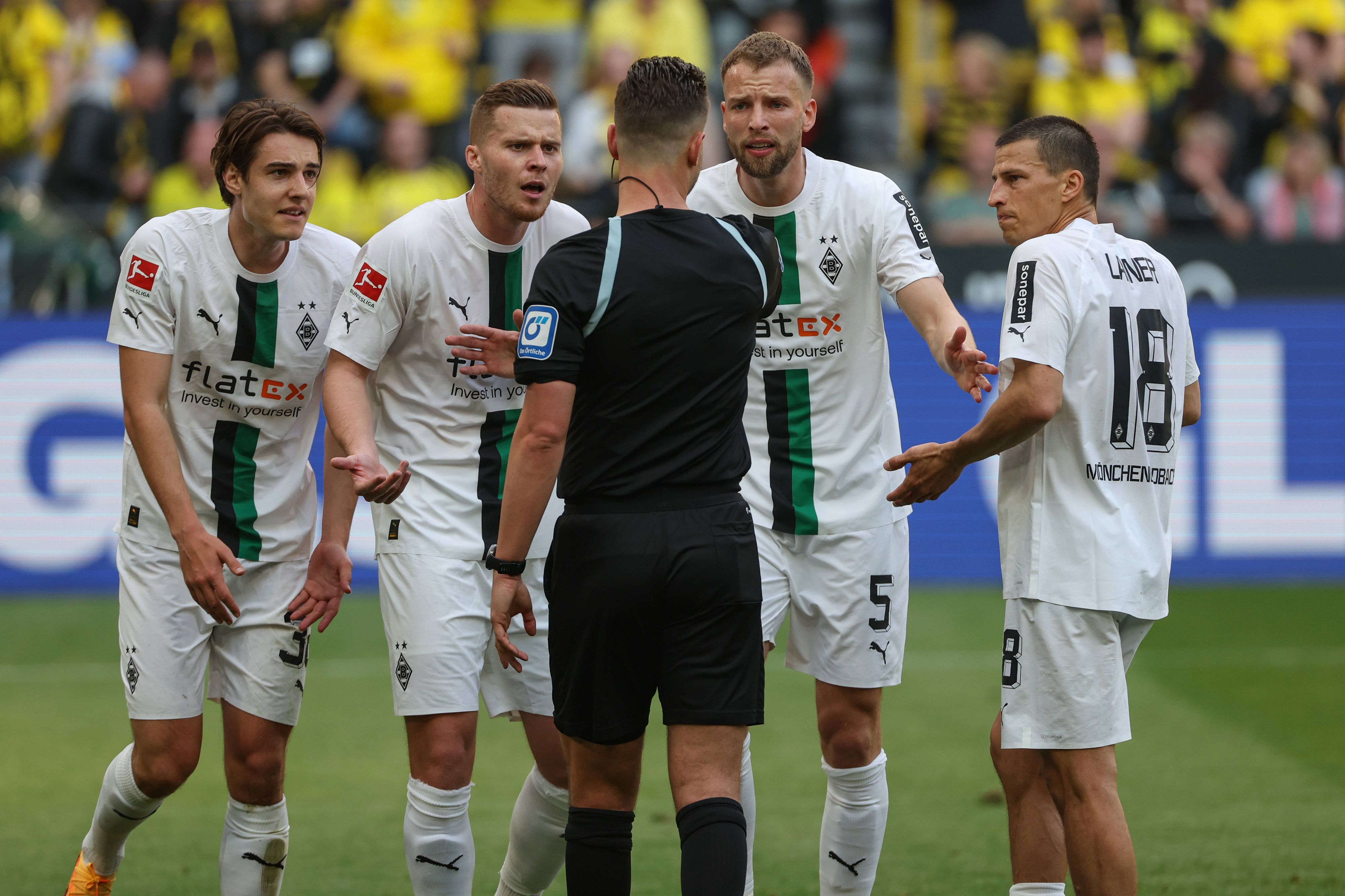 Spieler von Borussia Mönchengladbach beschweren sich im Spiel bei Borussia Dortmund am 13. Mai 2023 beim Schiedsrichter Daniel Schlager.