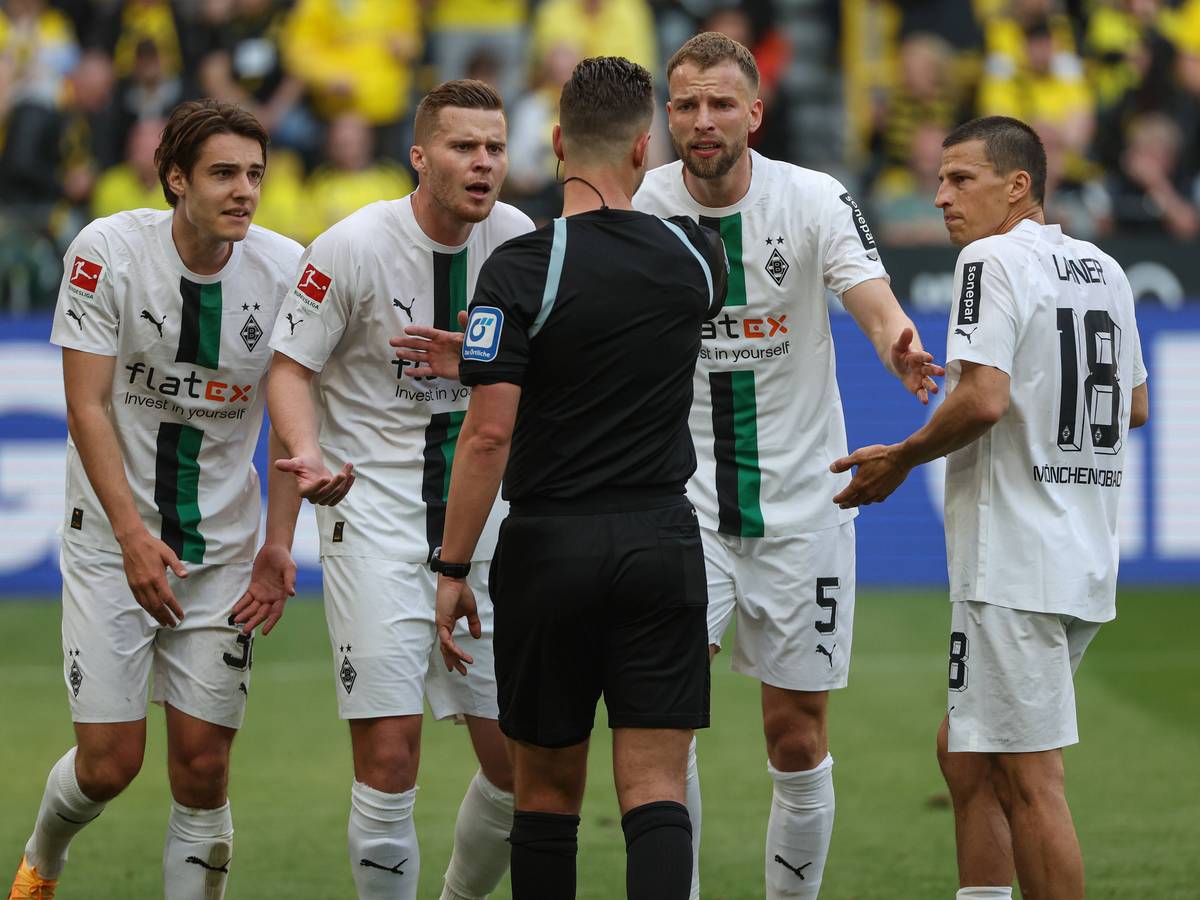 Spieler von Borussia Mönchengladbach beschweren sich im Spiel bei Borussia Dortmund am 13. Mai 2023 beim Schiedsrichter Daniel Schlager.