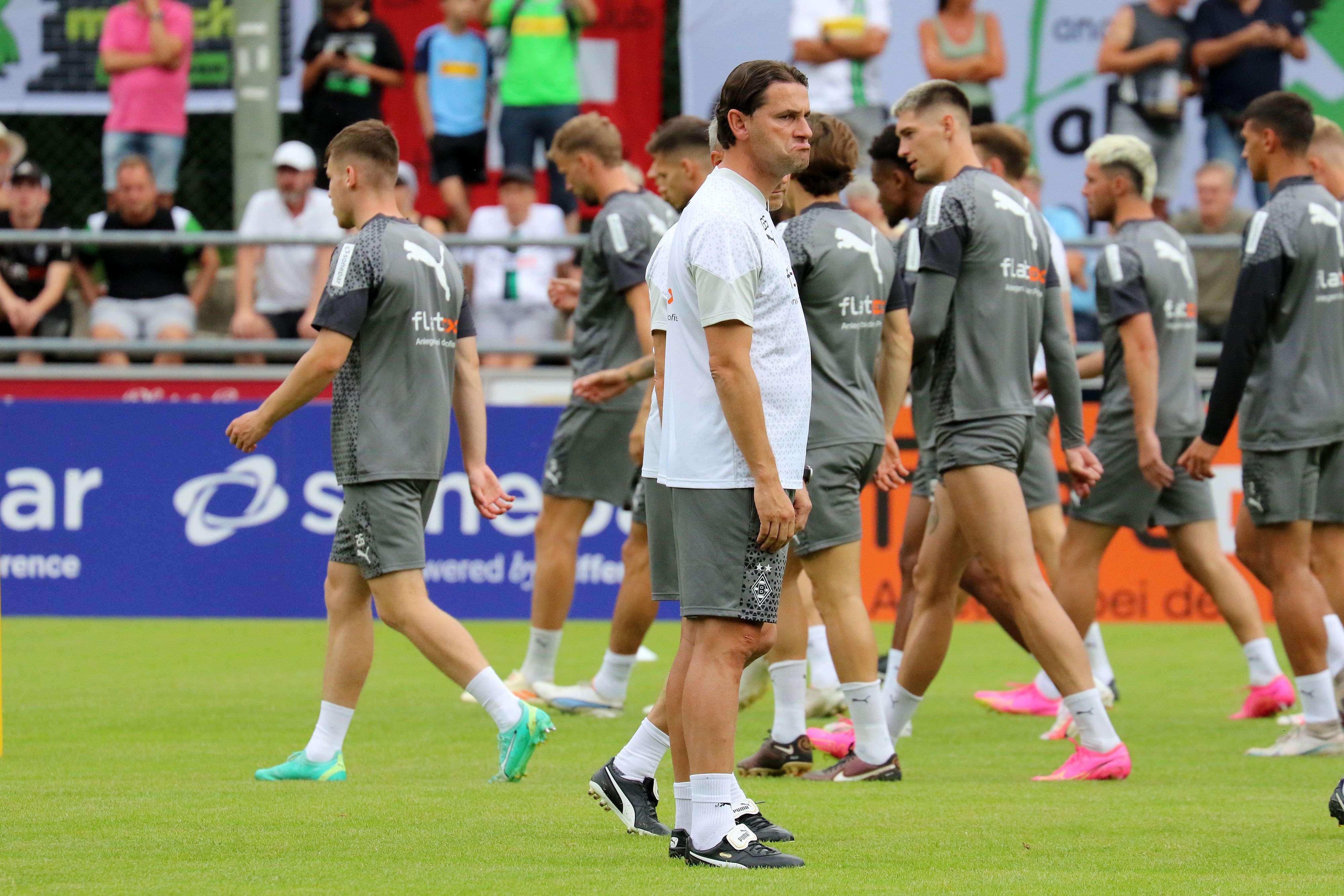 Gladbach-Trainer Gerardo Seoane (M.) hat einiges an Arbeit vor sich. Der Schweizer verpasst den Profis von Borussia Mönchengladbach im Trainingslager am Tegernsee den Feinschliff für die kommende Saison. Seoane schaut kritisch zur Seite.