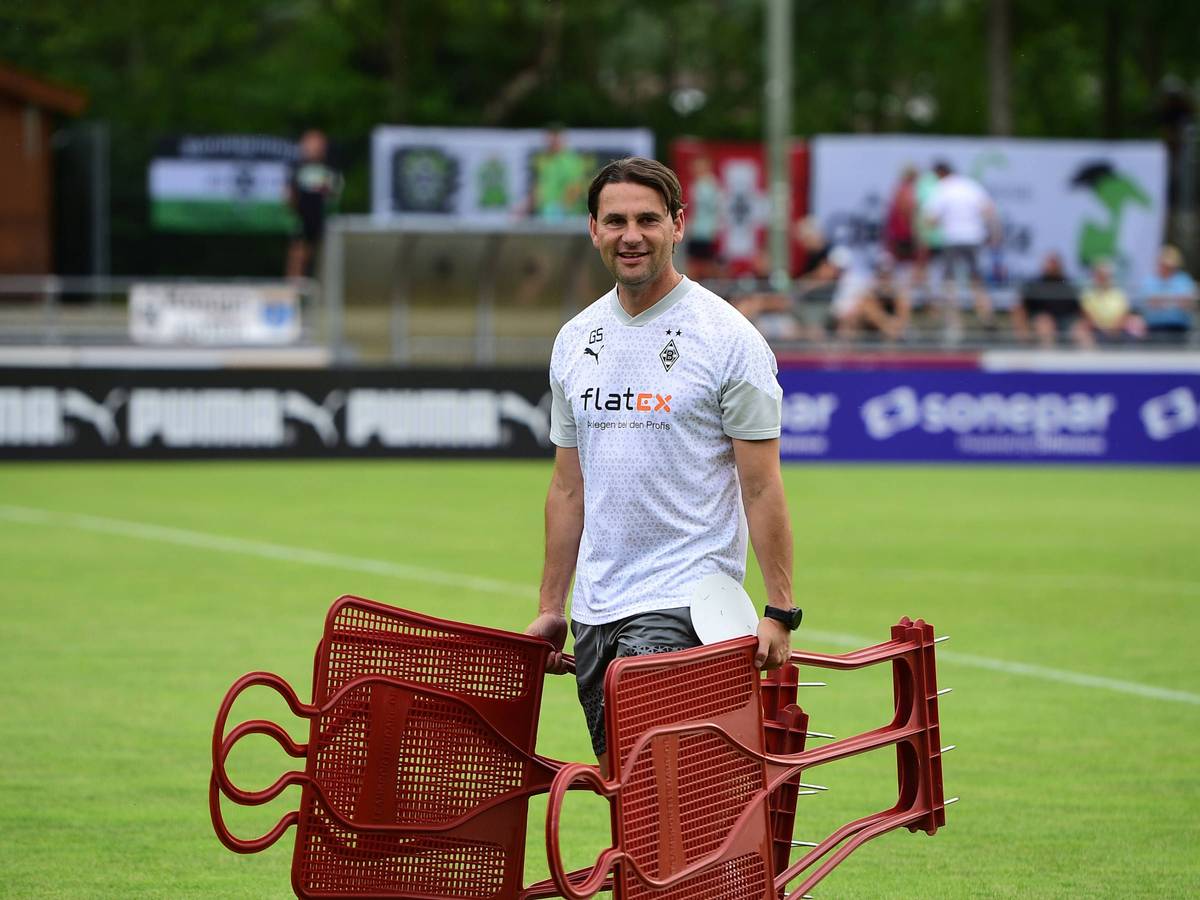 Gerardo Seoane hält am 23. Juli 2023 bei einer Einheit im Trainingslager in Rottach-Egern mehrere Spiel-Figuren in den Händen und steht auf dem Rasen am Sportplatz Birkenmoos.