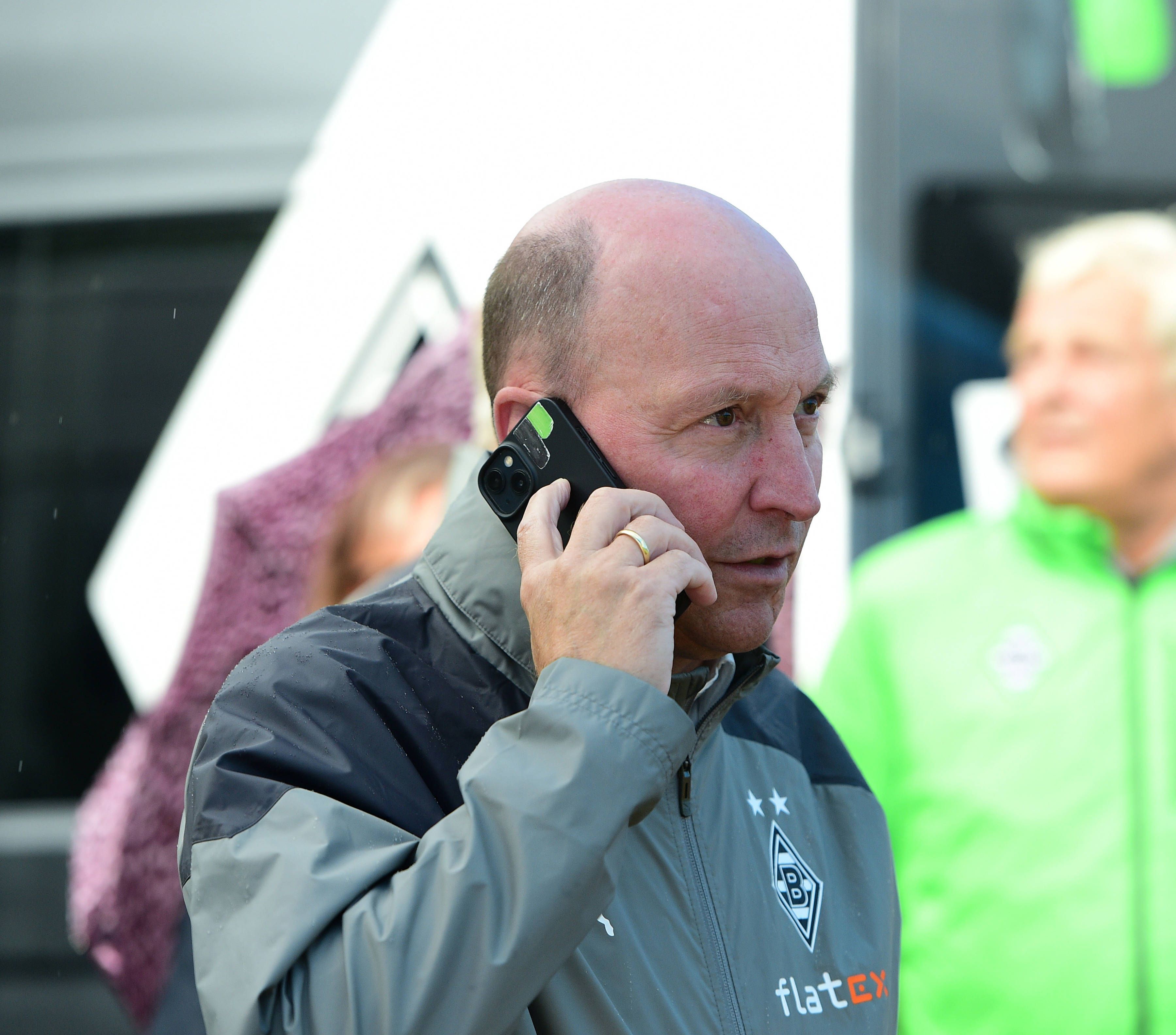 Akribisch und erfolgshungrig: Stephan Schippers hat aktuell jede Menge zu tun, um Borussia wieder zurück unter die nationalen Top-Vereine managen zu können. Auf diesem Foto telefoniert er am Rande des Gladbach-Testspiels (26. Juli 2023) am Tegernsee gegen den FC Ingolstadt. Schippers hält ein Smartphone an sein rechtes Ohr.
