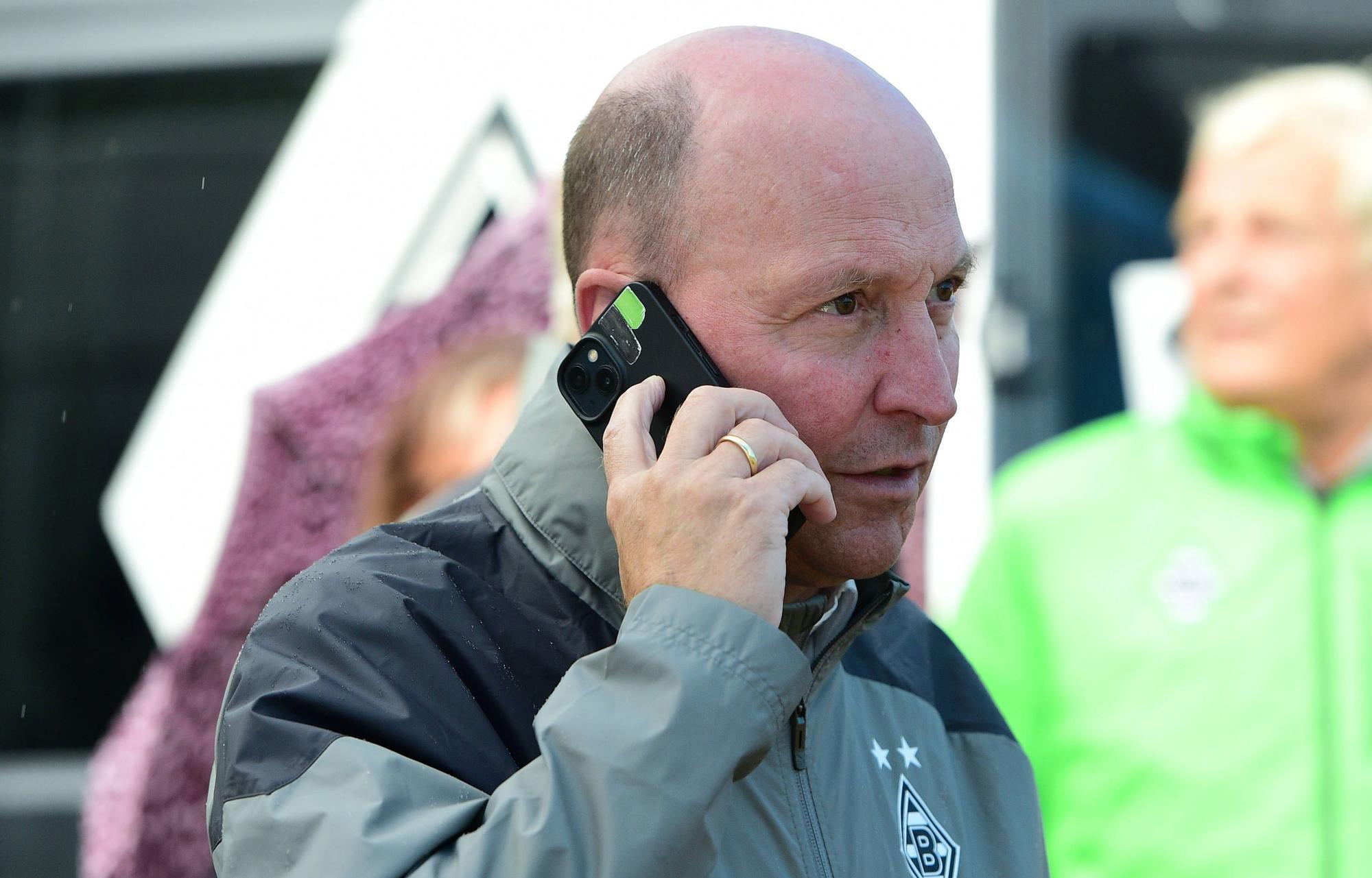 Akribisch und erfolgshungrig: Stephan Schippers hat aktuell jede Menge zu tun, um Borussia wieder zurück unter die nationalen Top-Vereine managen zu können. Auf diesem Foto telefoniert er am Rande des Gladbach-Testspiels (26. Juli 2023) am Tegernsee gegen den FC Ingolstadt. Schippers hält ein Smartphone an sein rechtes Ohr.