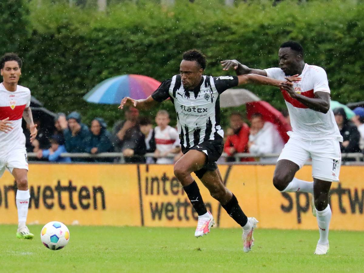 Nathan Ngoumou von Borussia Mönchengladbach (M.) im Testspiel am 29. Juli 2023 im Zweikampf mit Silas vom VfB Stuttgart (r.).