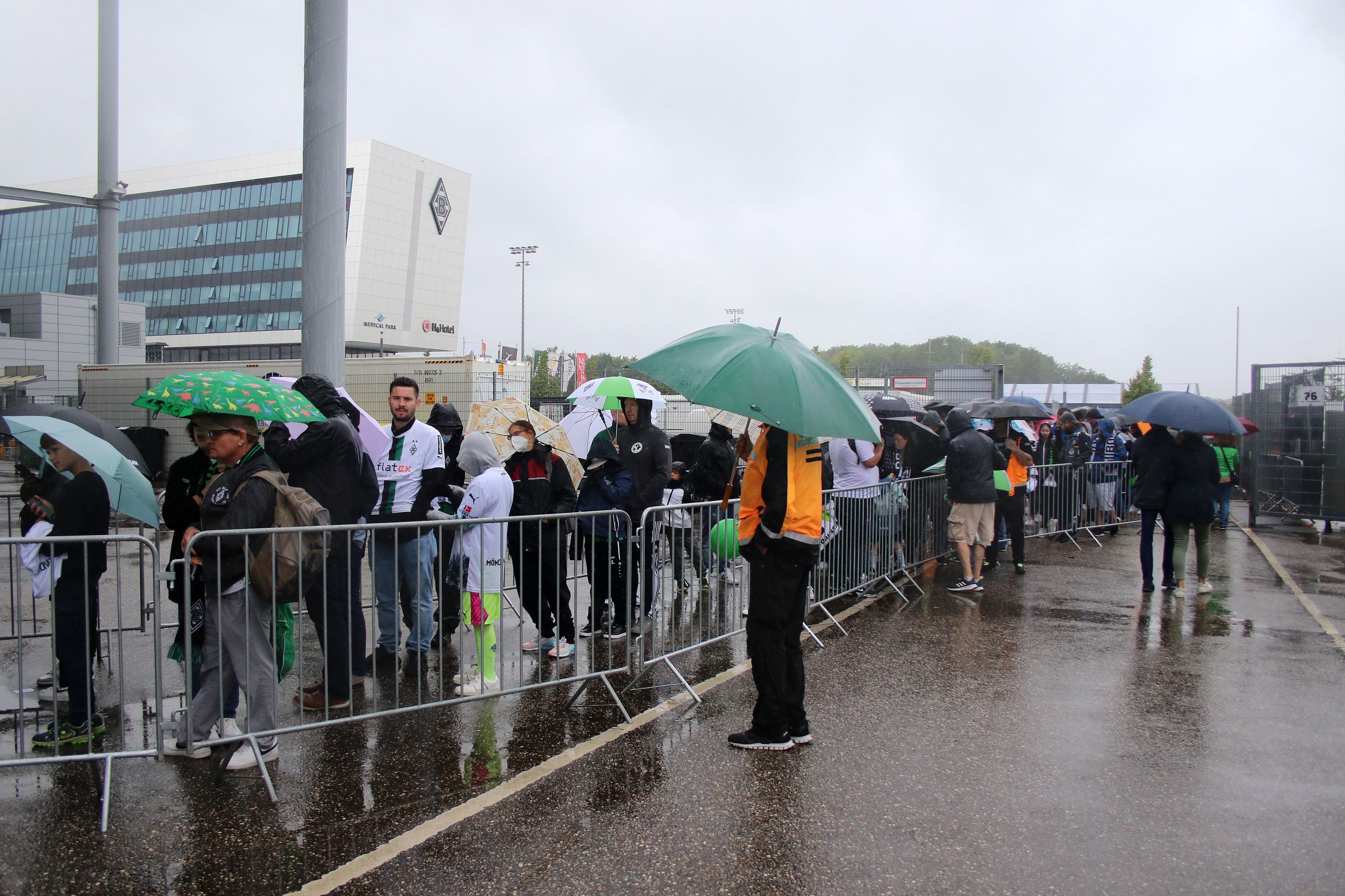Wir sind Borussi-JA! Tausende Gladbach-Fans stehen trotz Dauerregens am Sonntag (6. August 2023) beim Familienfest samt Saisoneröffnung im Borussia-Park an, um Autogramme von den Fohlen-Stars erhaschen zu können. Zu sehen ist eine Menschenschlange und zahlreiche Regenschirme.