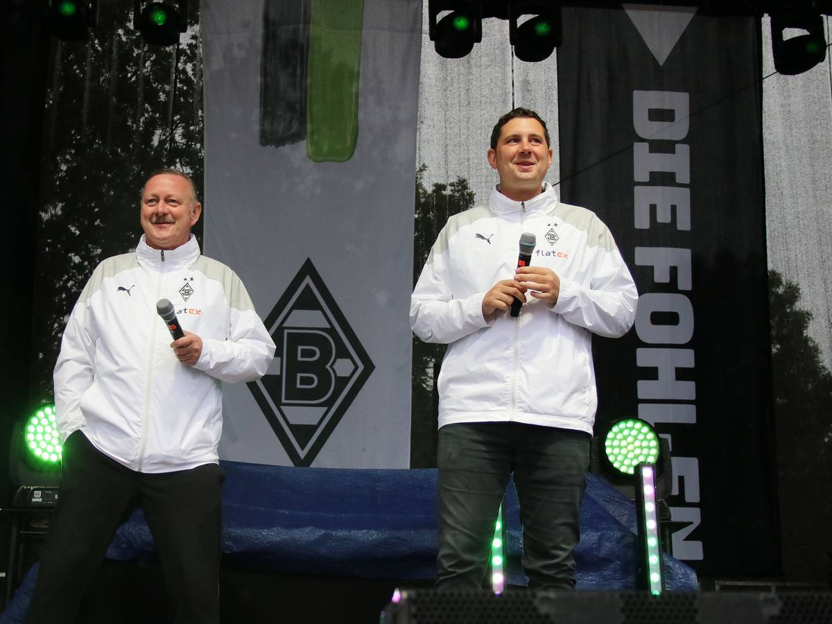 Manager Roland Virkus (l.) und Sportdirektor Nils Schmadtke (r.), hier zu sehen bei der Saisoneröffnung (6. August 2023) von Fußball-Bundesligist Borussia Mönchengladbach. Die beiden stehen auf einer Bühne und halten jeweils ein Mikrofon in ihren Händen.