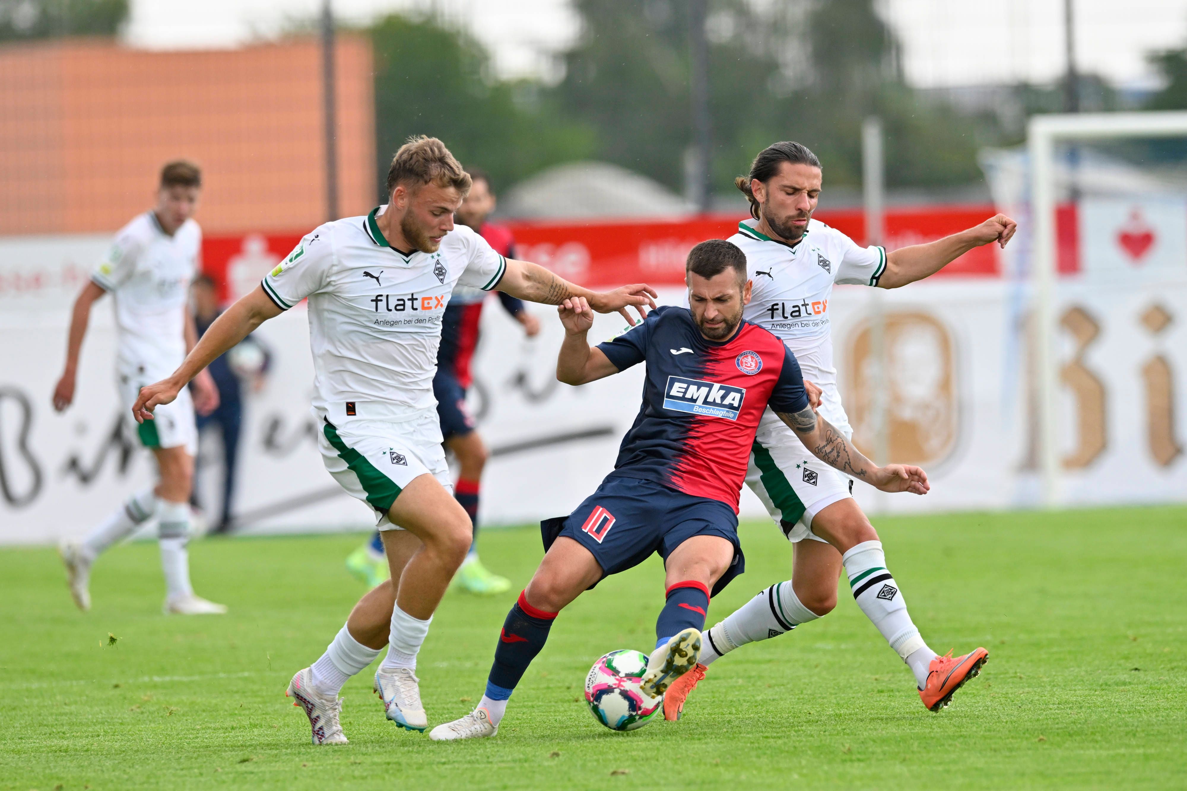 Borussia Mönchengladbach hat am Samstag (5. August 2023) 2:3 beim Wuppertaler SV in der Regionalliga West verloren. Das Foto zeigt Mika Schroers (l.) und Julian Korb (r.) im Duell mit Wuppertals Noah Raphael Andreas (Mitte).