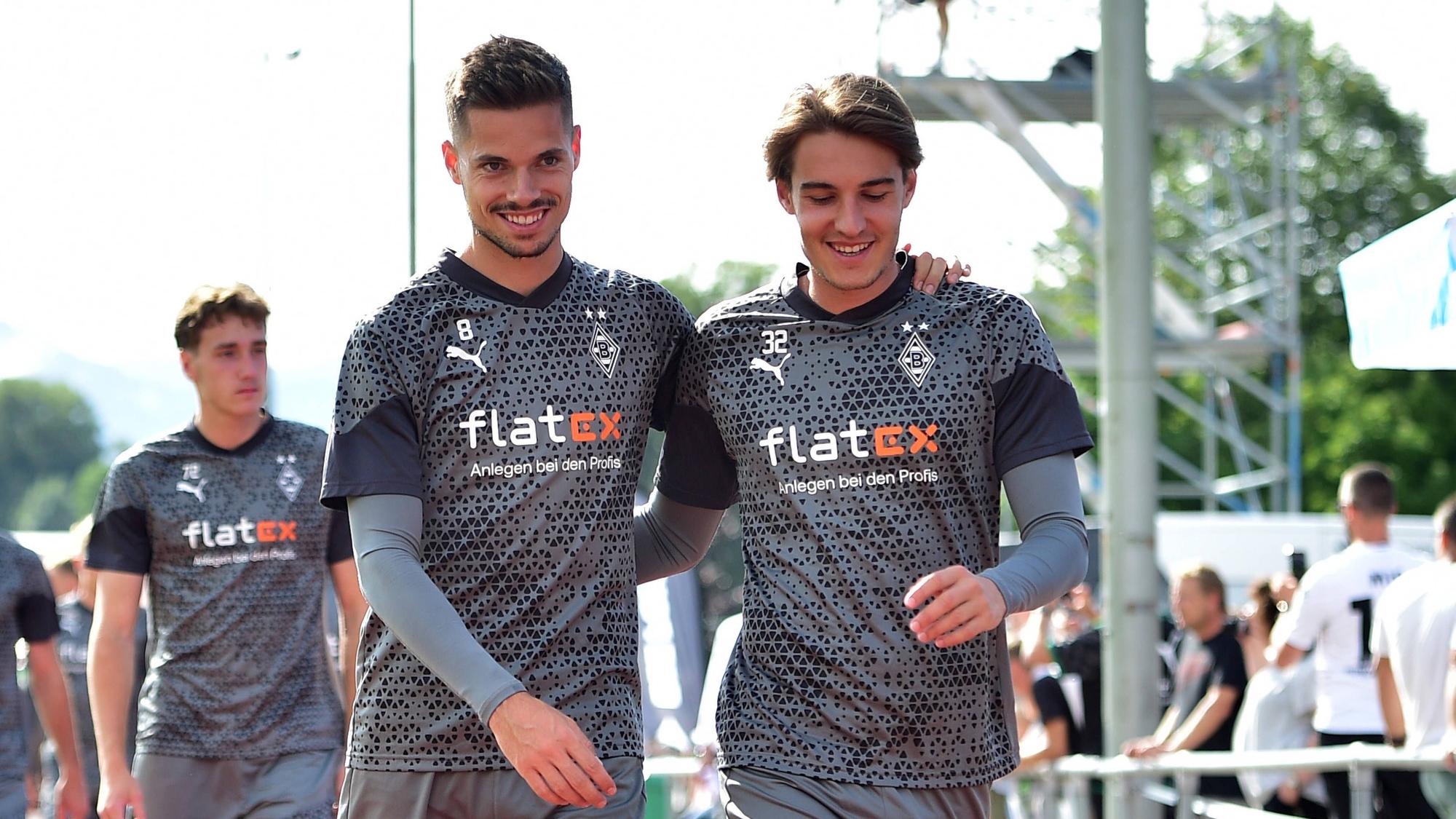 Gladbach-Profi Florian Neuhaus (r.) mit Teamkollege Julian Weigl (l.), hier zu sehen am 24. Juli 2023 während des Borussia-Trainingslagers in Rottach-Egern. Die beiden umarmen sich.