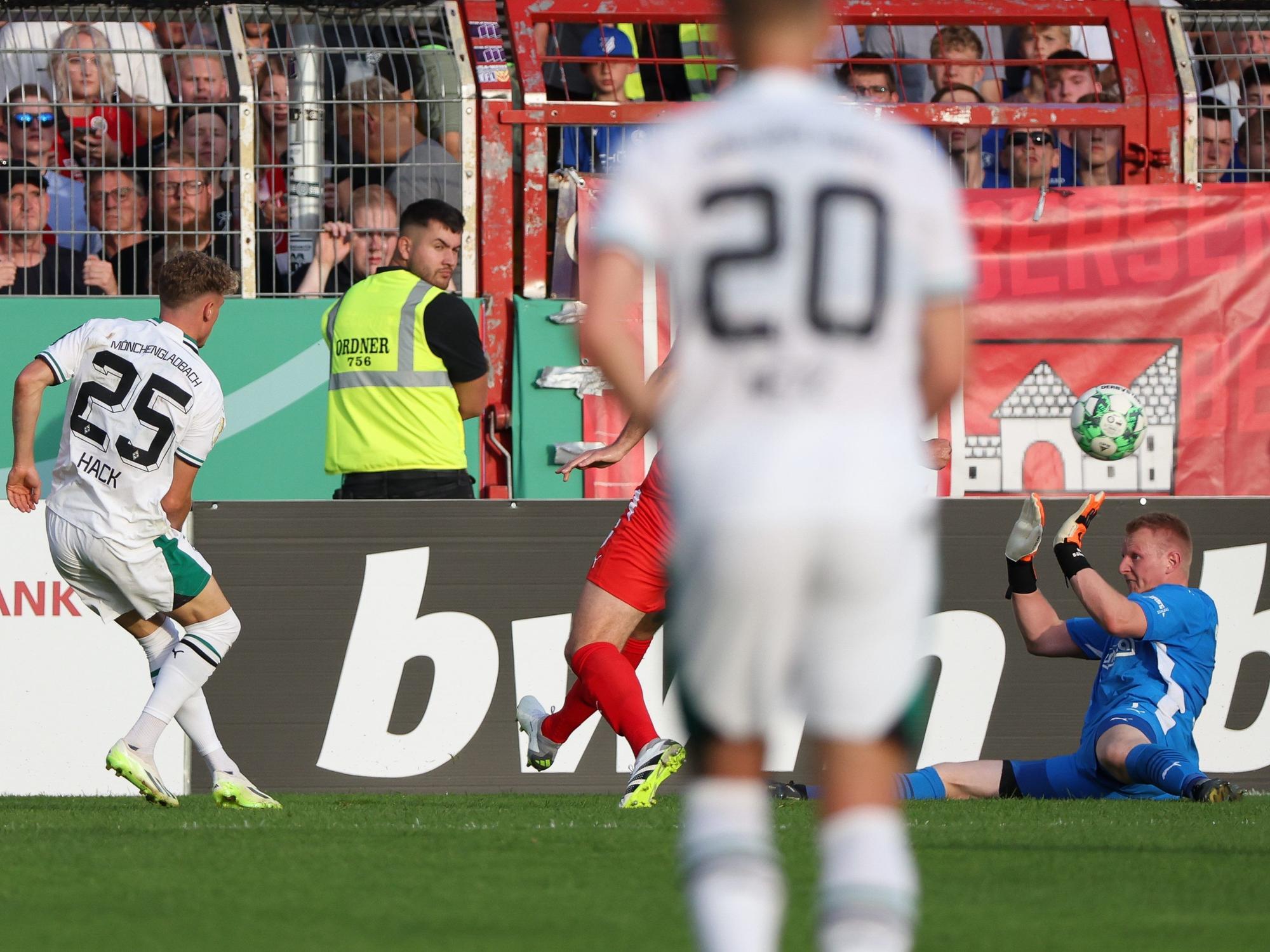 Gladbachs Torschütze Robin Hack (l) erzielt den Treffer zum 0:6 gegen Bersenbrücks Torwart Nils Böhmann (r).