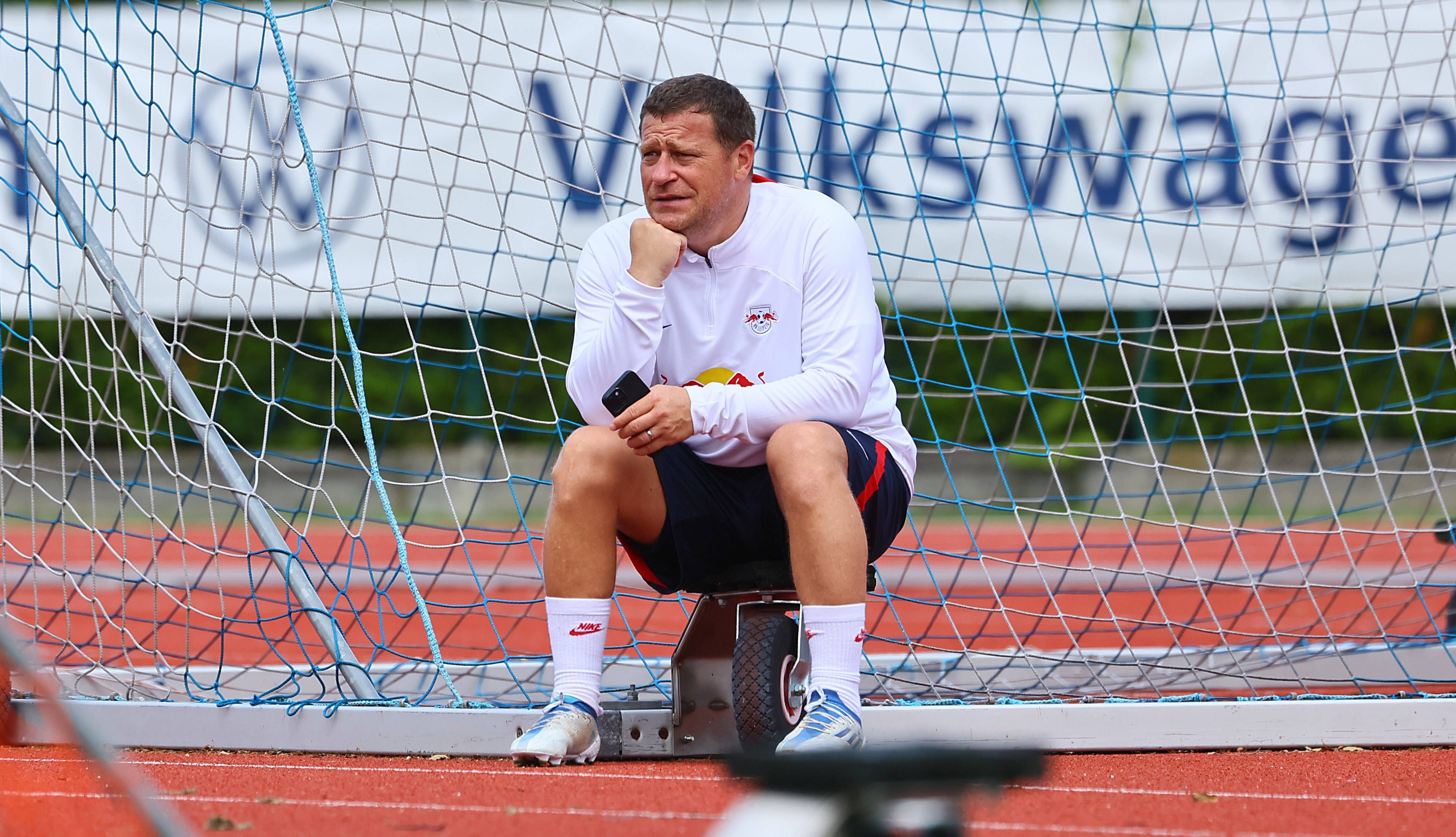 Max Eberl sitzt am Rande des Trainingsplatzes von RB Leipzig.