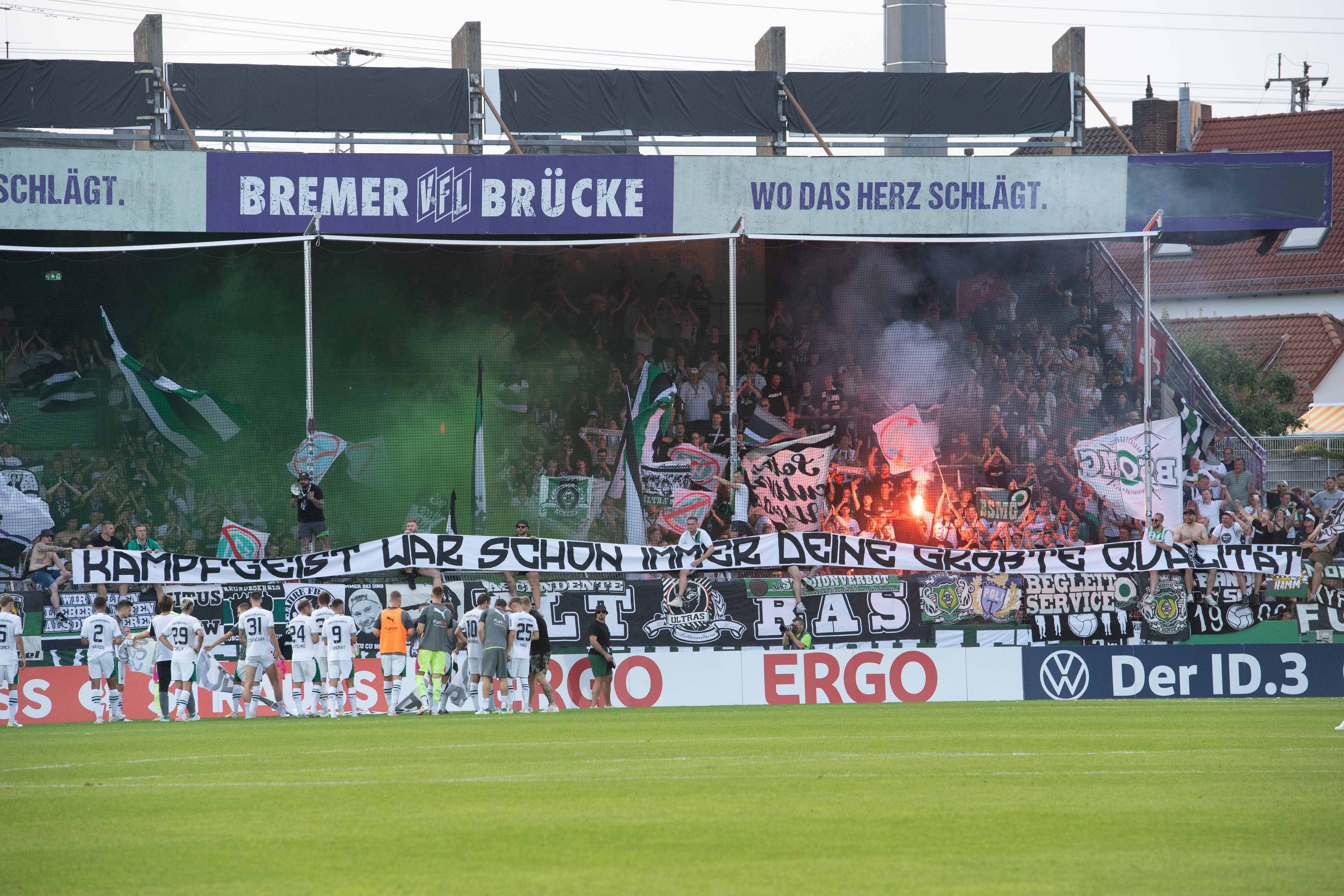 Die Fans von Borussia Mönchengladbach zeigen nach dem DFB-Pokalspiel am 11. August 2023 beim TuS Bersenbrück ein Banner mit einer Botschaft an Stefan Lainer: „Kampfgeist war schon immer deine größte Qualität“.