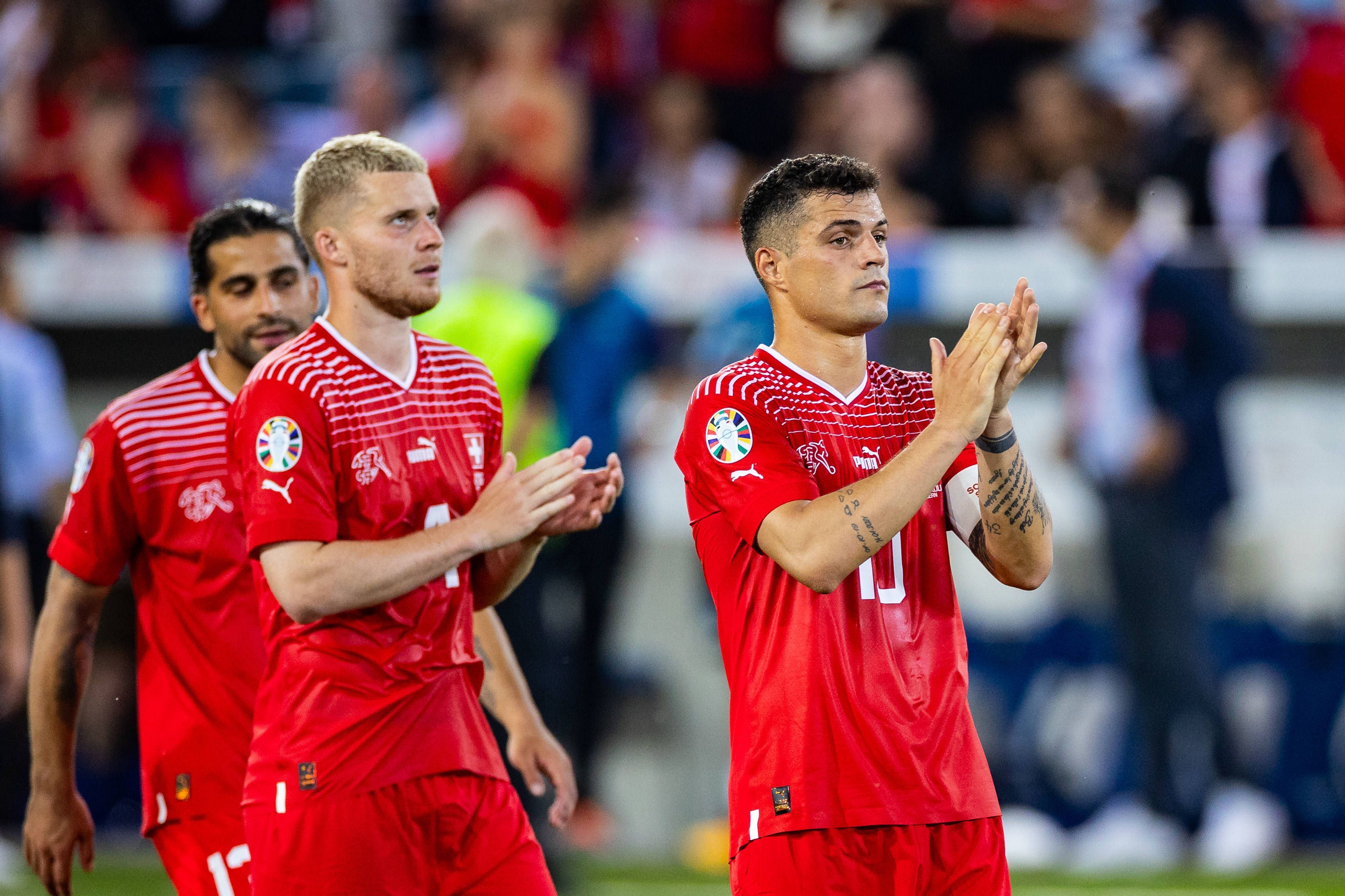 Nico Elvedi (M.), Ricardo Rodríguez (l.) und Granit Xhaka beklatschen die Unterstützung der Fans der Schweizer Nationalmannschaft am 19. Juni 2023.