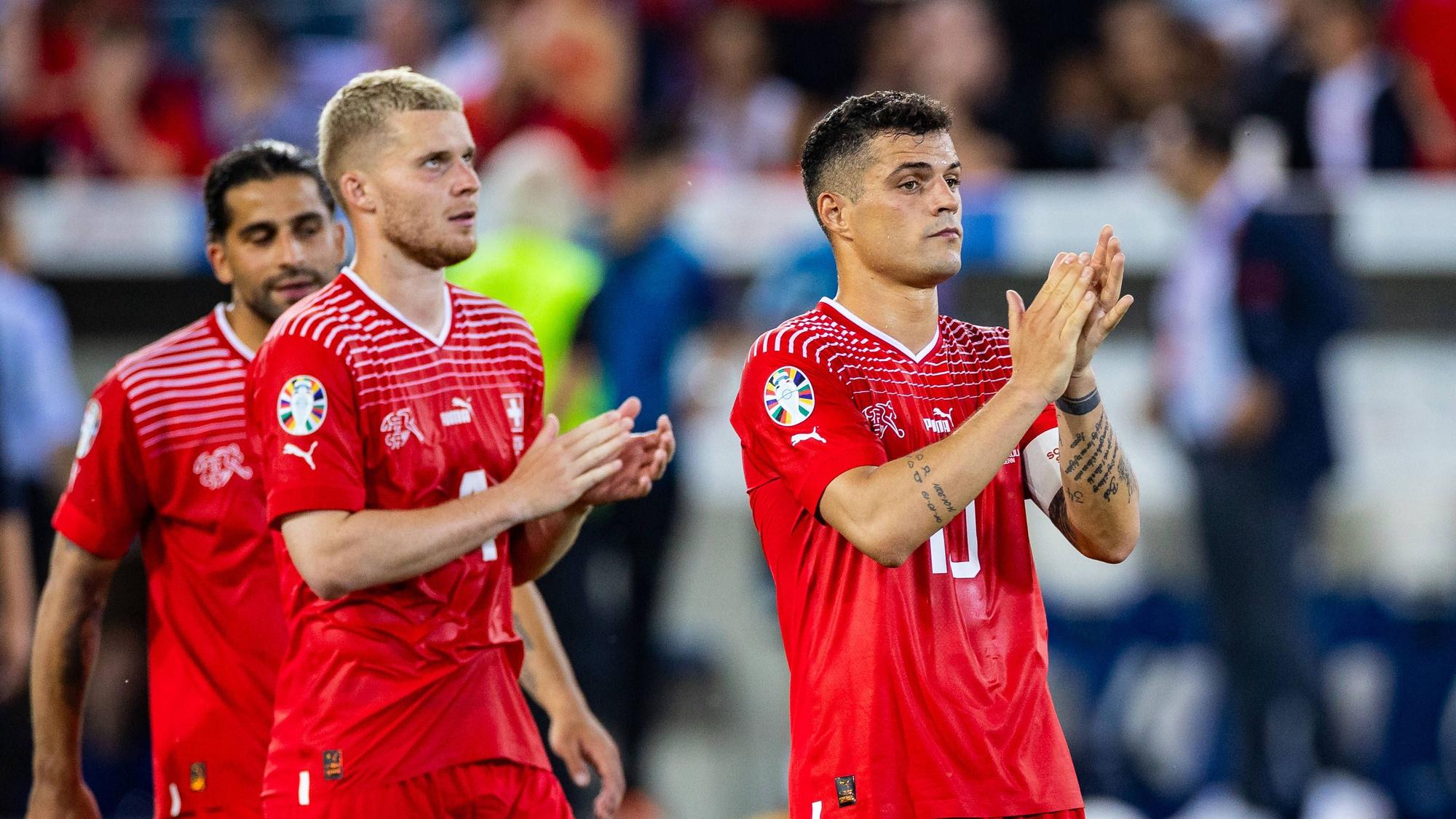 Nico Elvedi (M.), Ricardo Rodríguez (l.) und Granit Xhaka beklatschen die Unterstützung der Fans der Schweizer Nationalmannschaft am 19. Juni 2023.