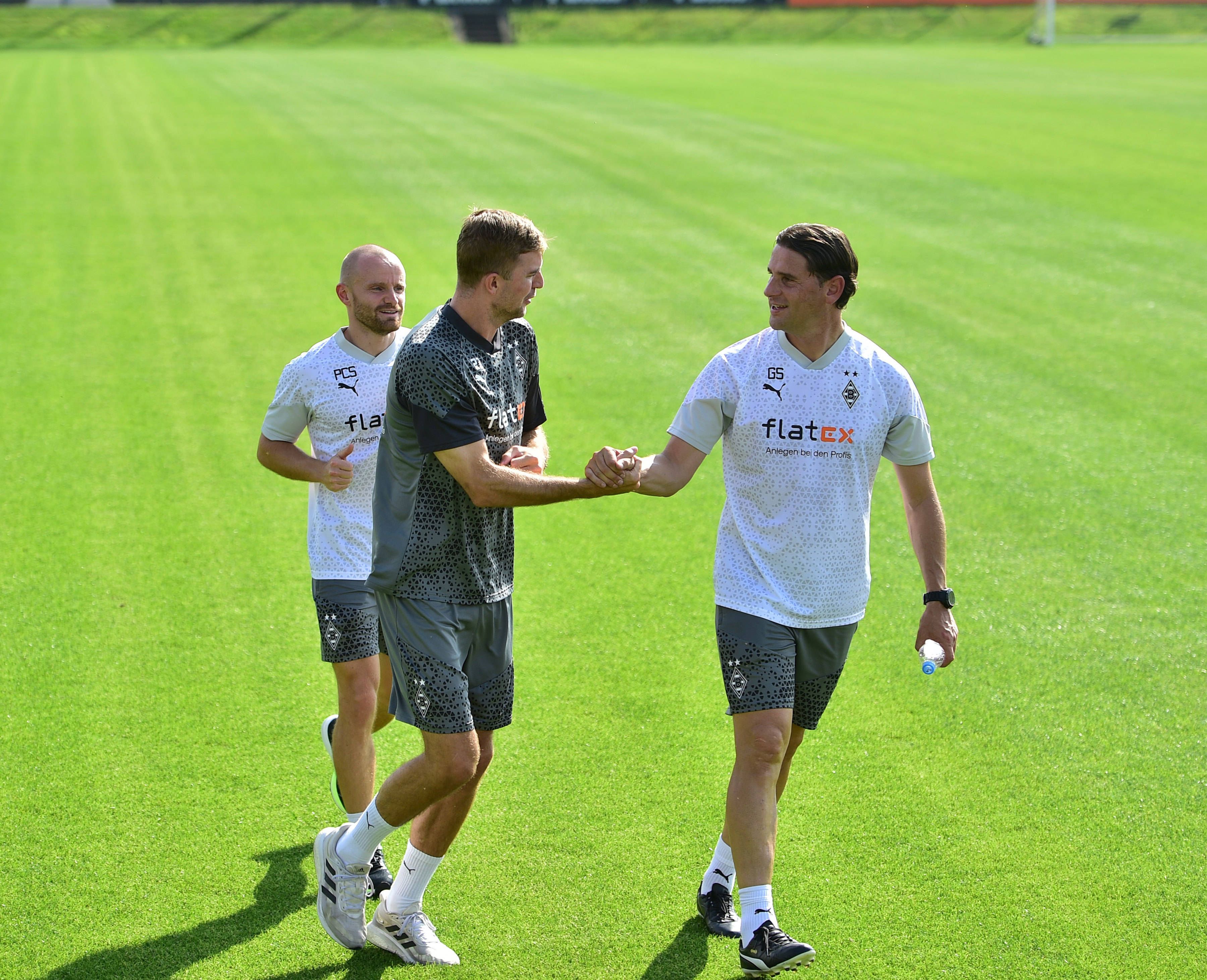 Gerardo Seoane (r.) schlägt am 14. August 2023 mit Christoph Kramer (M.) auf dem Trainingsplatz von Borussia Mönchengladbach ein.