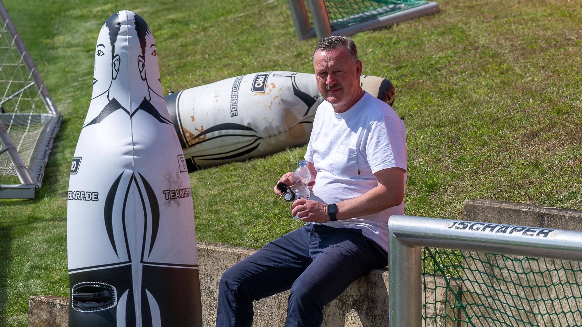 Roland Virkus sitzt am 14. August 2023 bei einem Training auf einem Mauer auf dem Vereins-Gelände im Borussia-Park.