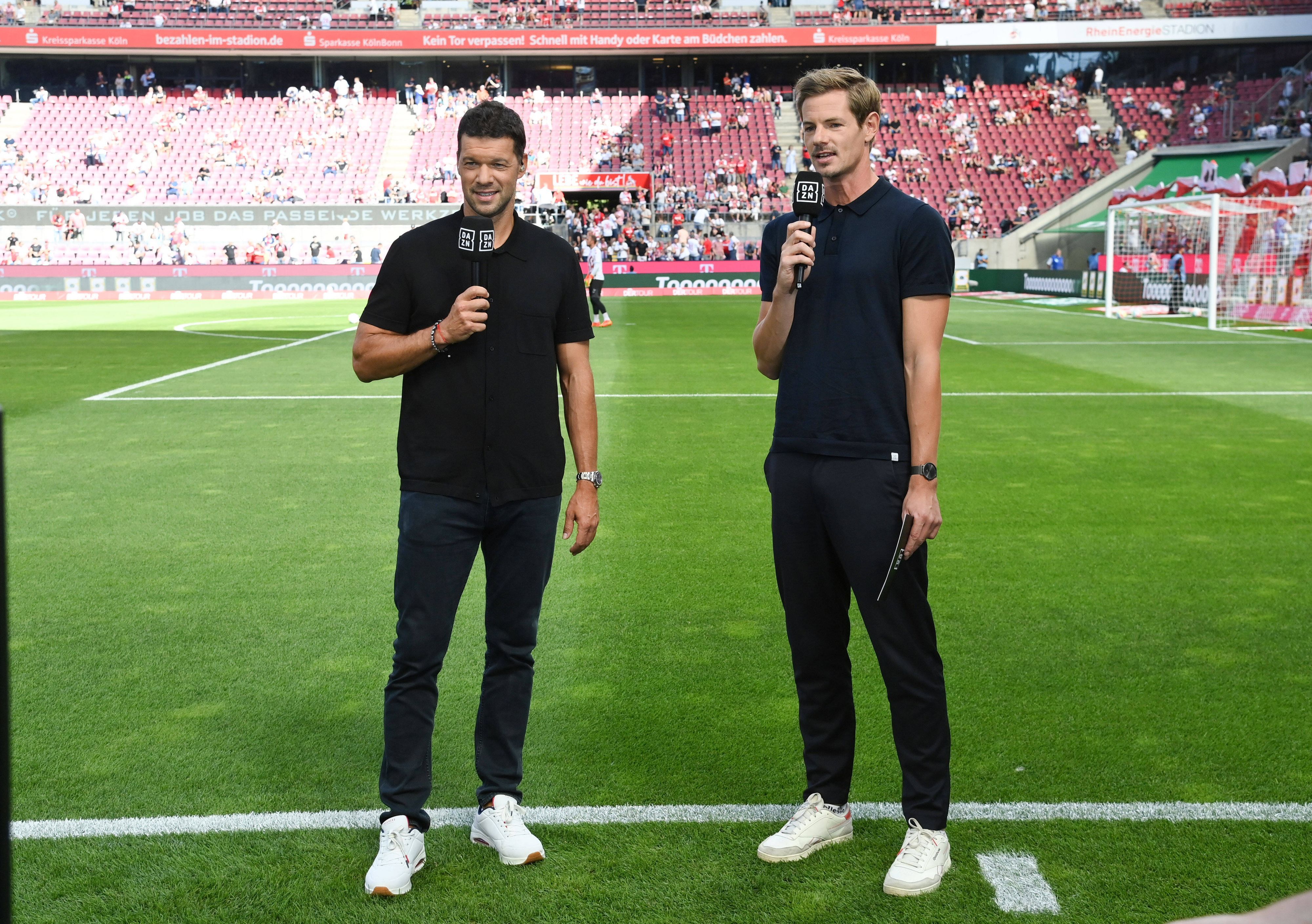 Ex-Nationalspieler Michael Ballack (l.) und Moderator Alex Schlüter stehen am 7. August 2022 vor einem Bundesliga-Spiel im Kölner Stadion.