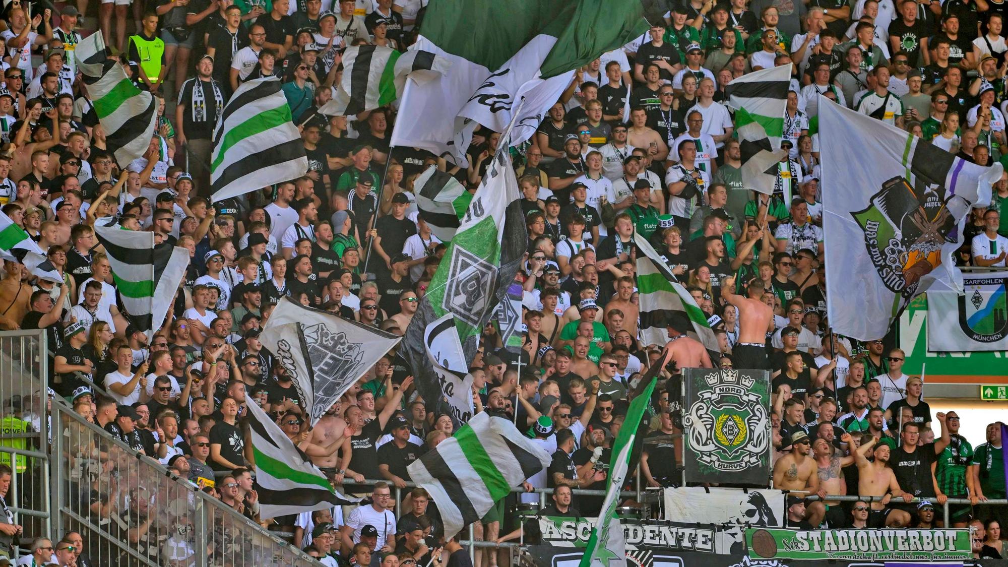 Die Fans von Borussia Mönchengladbach im Fanblock beim Auswärtsspiel in Augsburg am 19. August 2023.