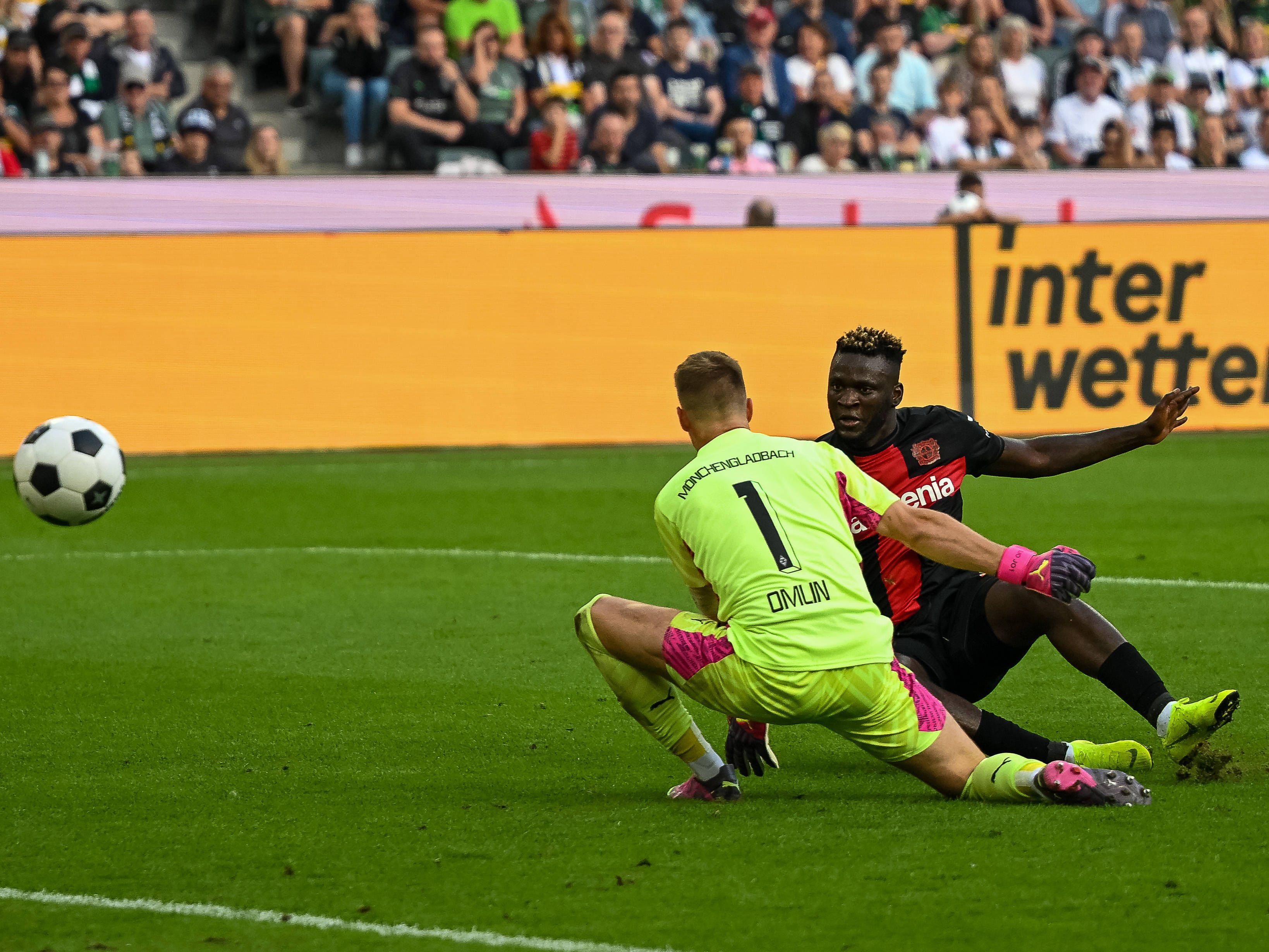 Victor Boniface (r.) trifft am 26. August 2023 zum zwischenzeitlichen 3:0 für Bayer Leverkusen gegen Borussia Mönchengladbach, Torwart Jonas Omlin ist machtlos.