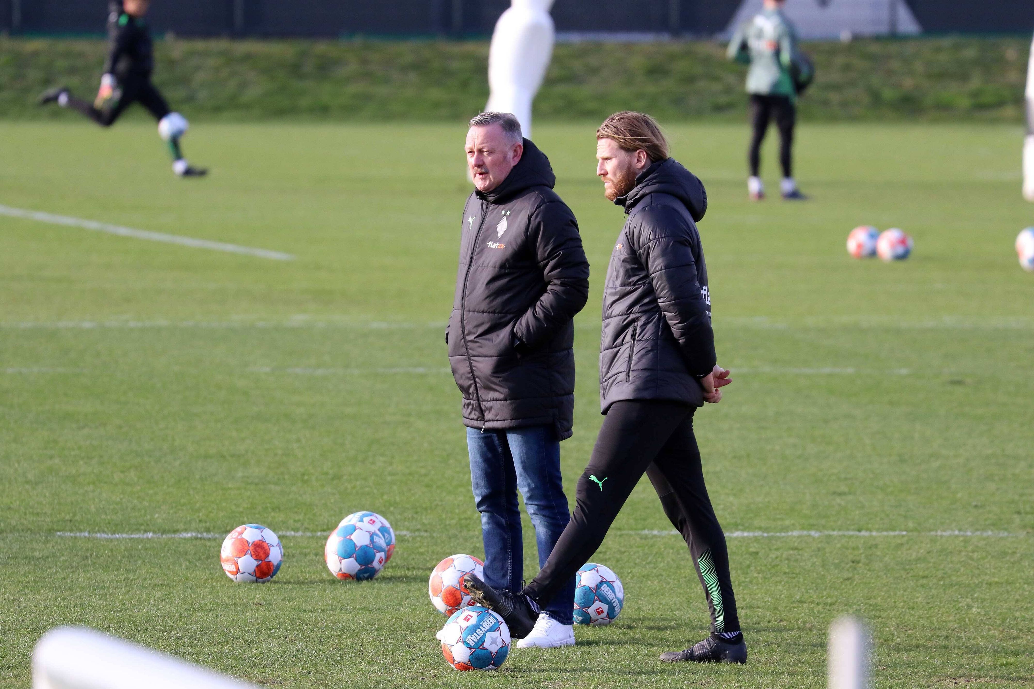 Roland Virkus (l.) und Eugen Polanski beobachten eine Trainings-Einheit am 15. Februar 2022.