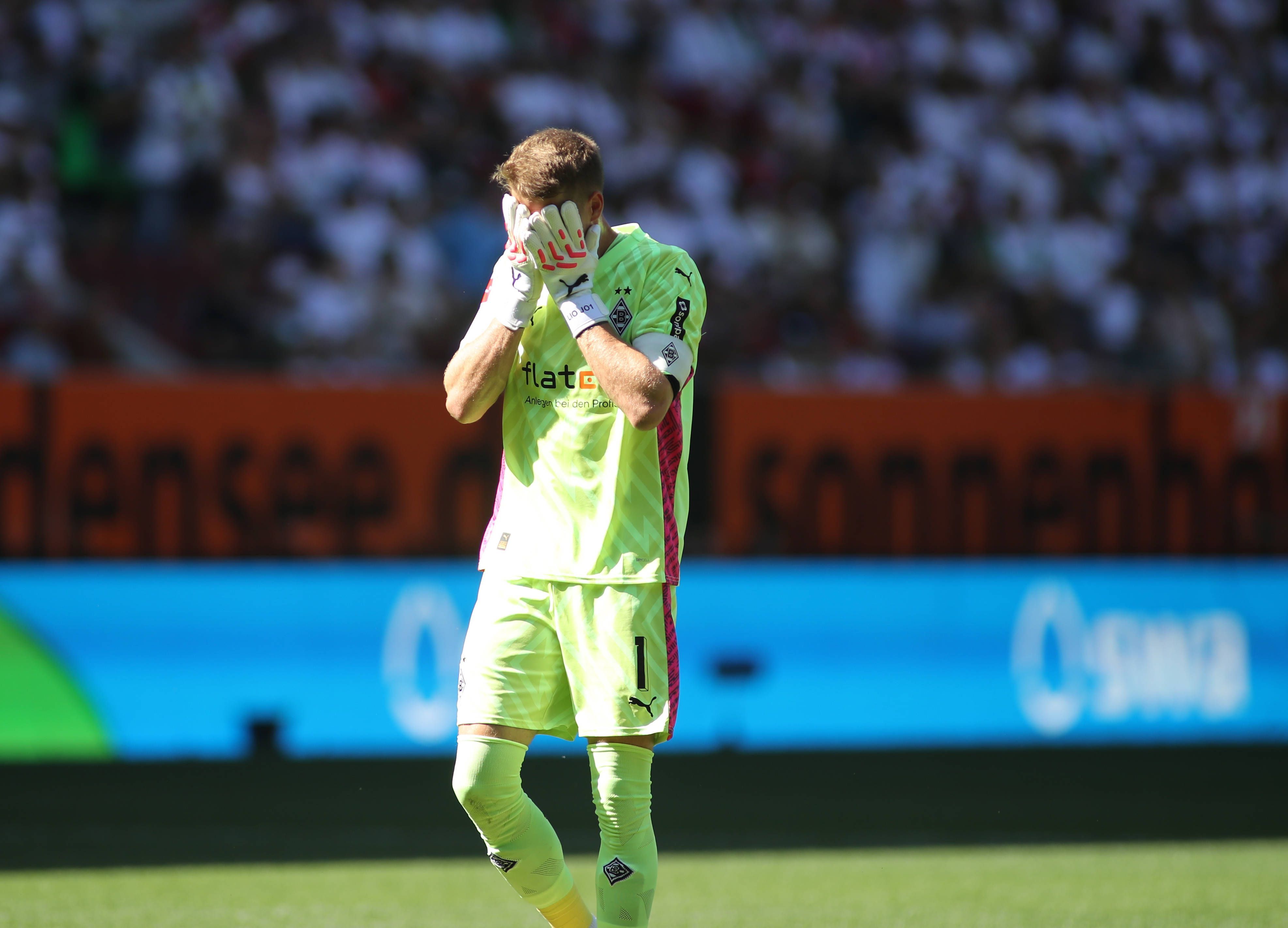 Jonas Omlin fasst sich beim Bundesliga-Spiel von Borussia Mönchengladbach in Augsburg am 19. August 2023 mit den Handschuhen ins Gesicht.