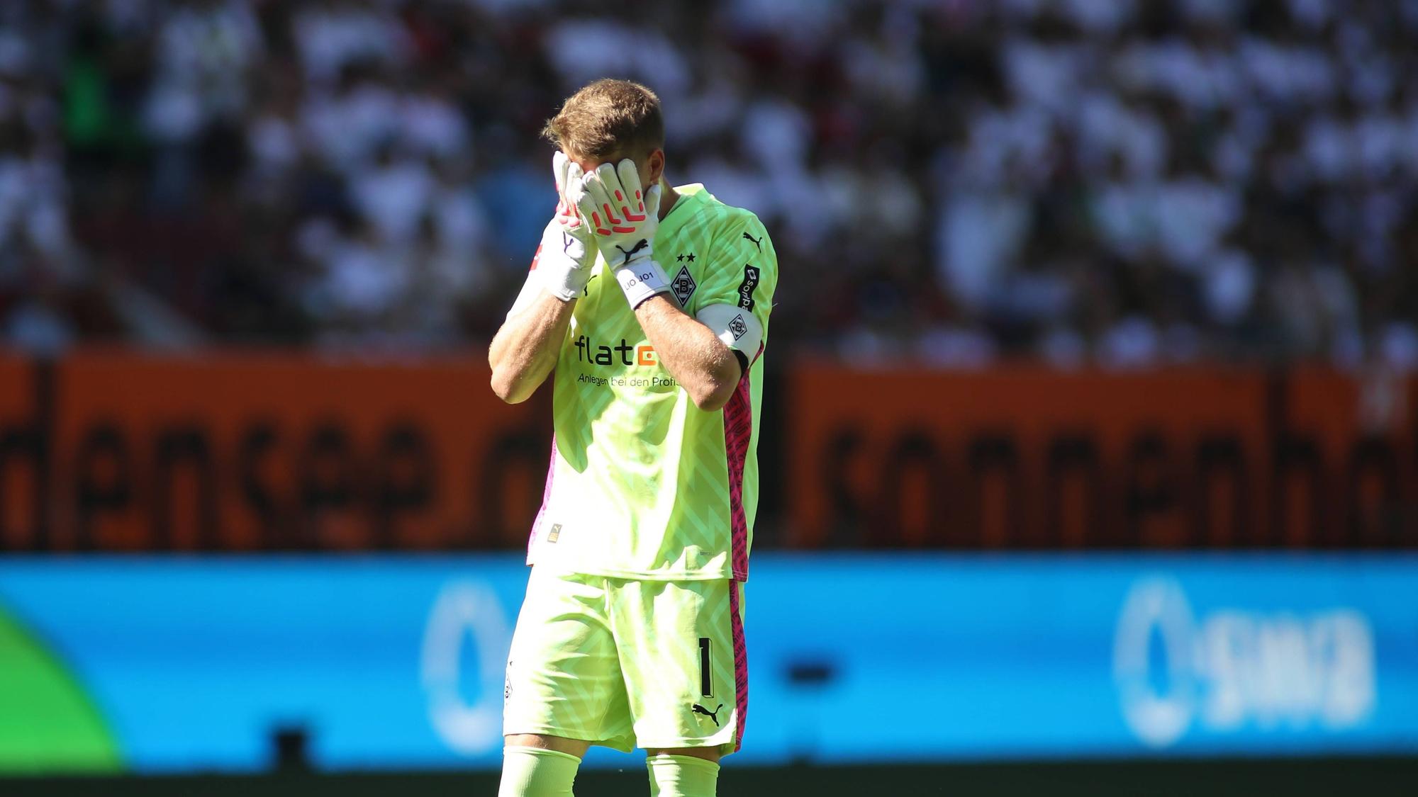 Jonas Omlin fasst sich beim Bundesliga-Spiel von Borussia Mönchengladbach in Augsburg am 19. August 2023 mit den Handschuhen ins Gesicht.