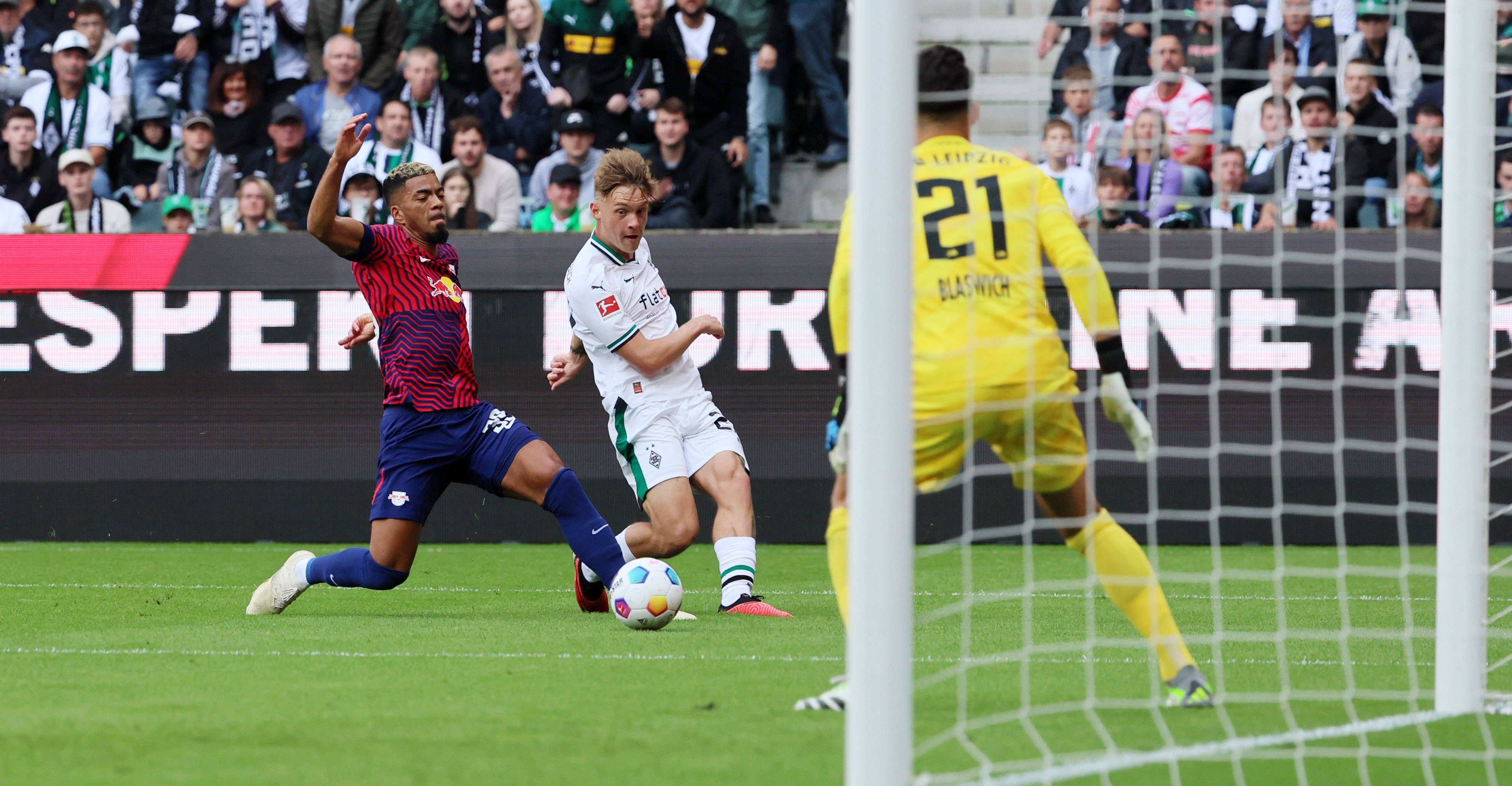 Luca Netz (M.) spielt einen Ball flach in den Strafraum von RB Leipzig.