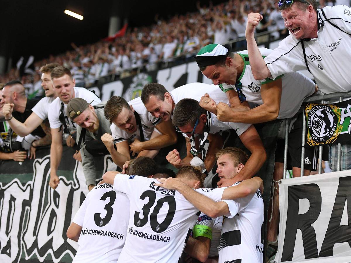 Spieler von Borussia Mönchengladbach feiern mit Gladbach-Fans in der Nordkurve.