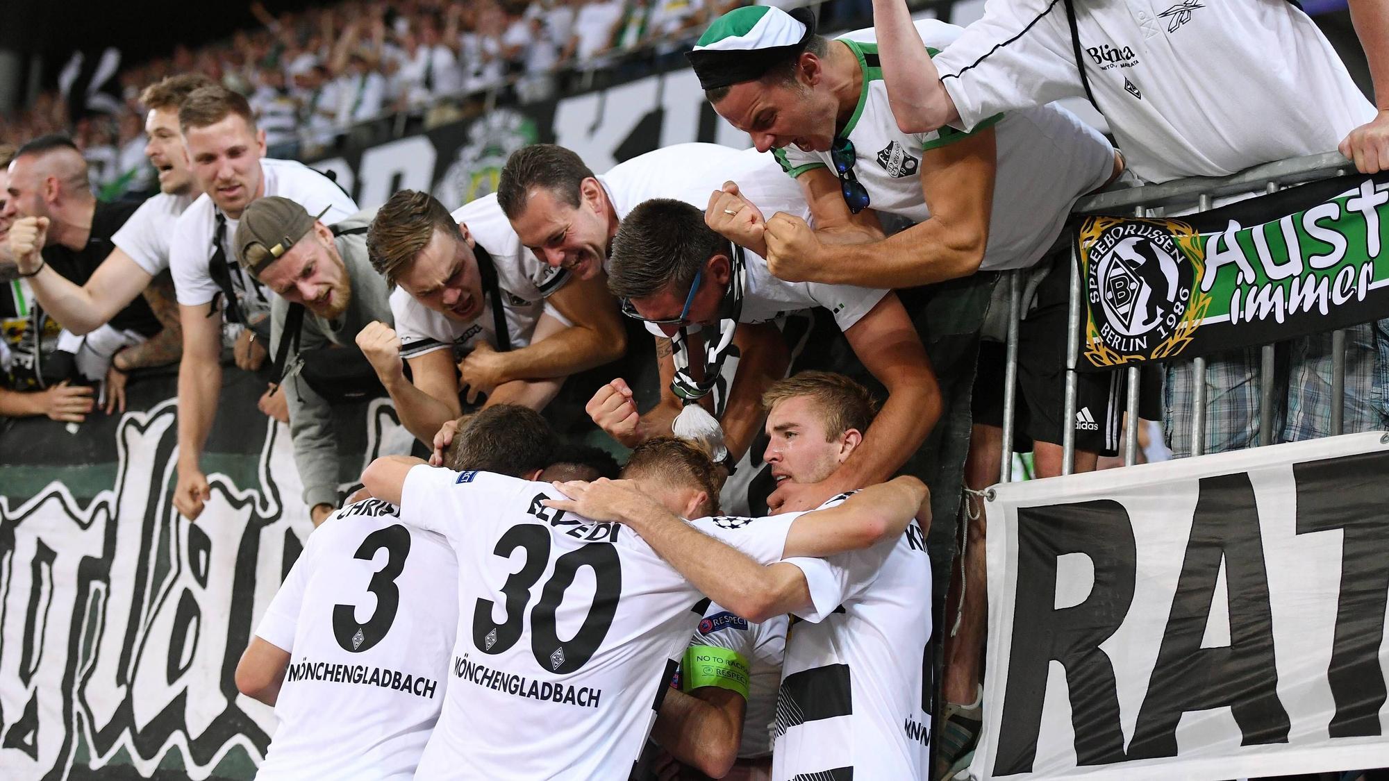 Spieler von Borussia Mönchengladbach feiern mit Gladbach-Fans in der Nordkurve.