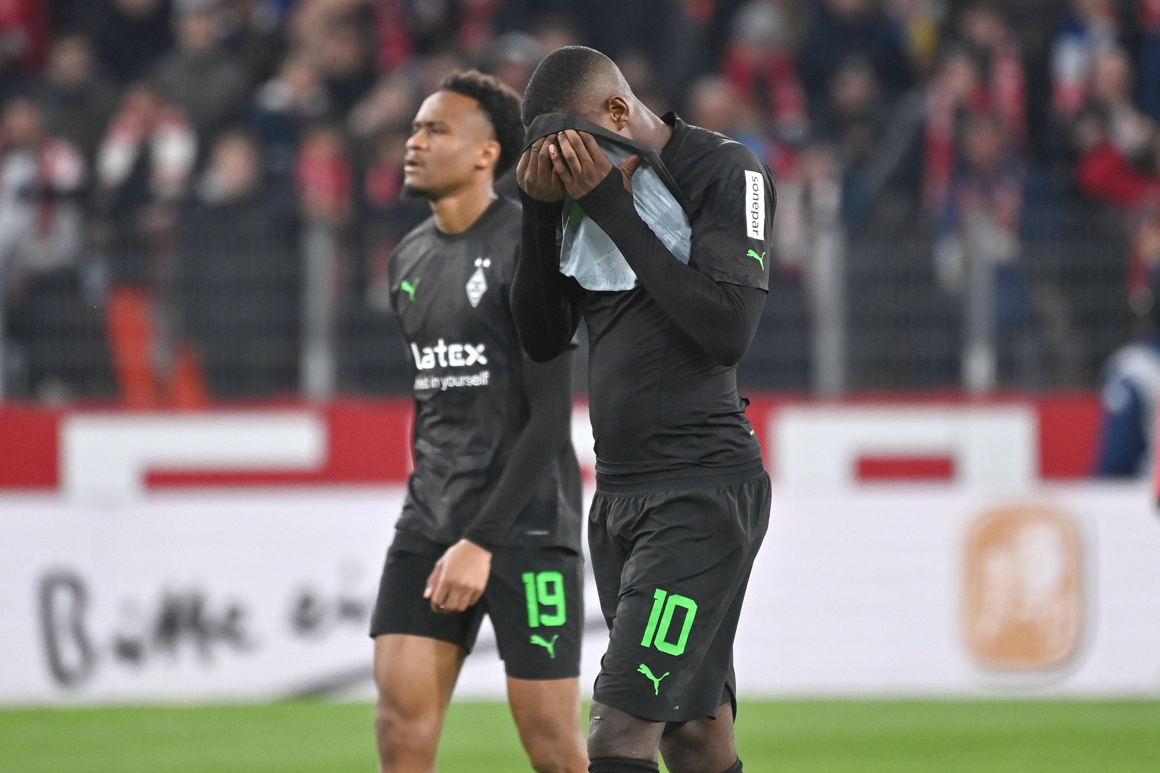 Marcus Thuram hält sich das Trikot vor das Gesicht.