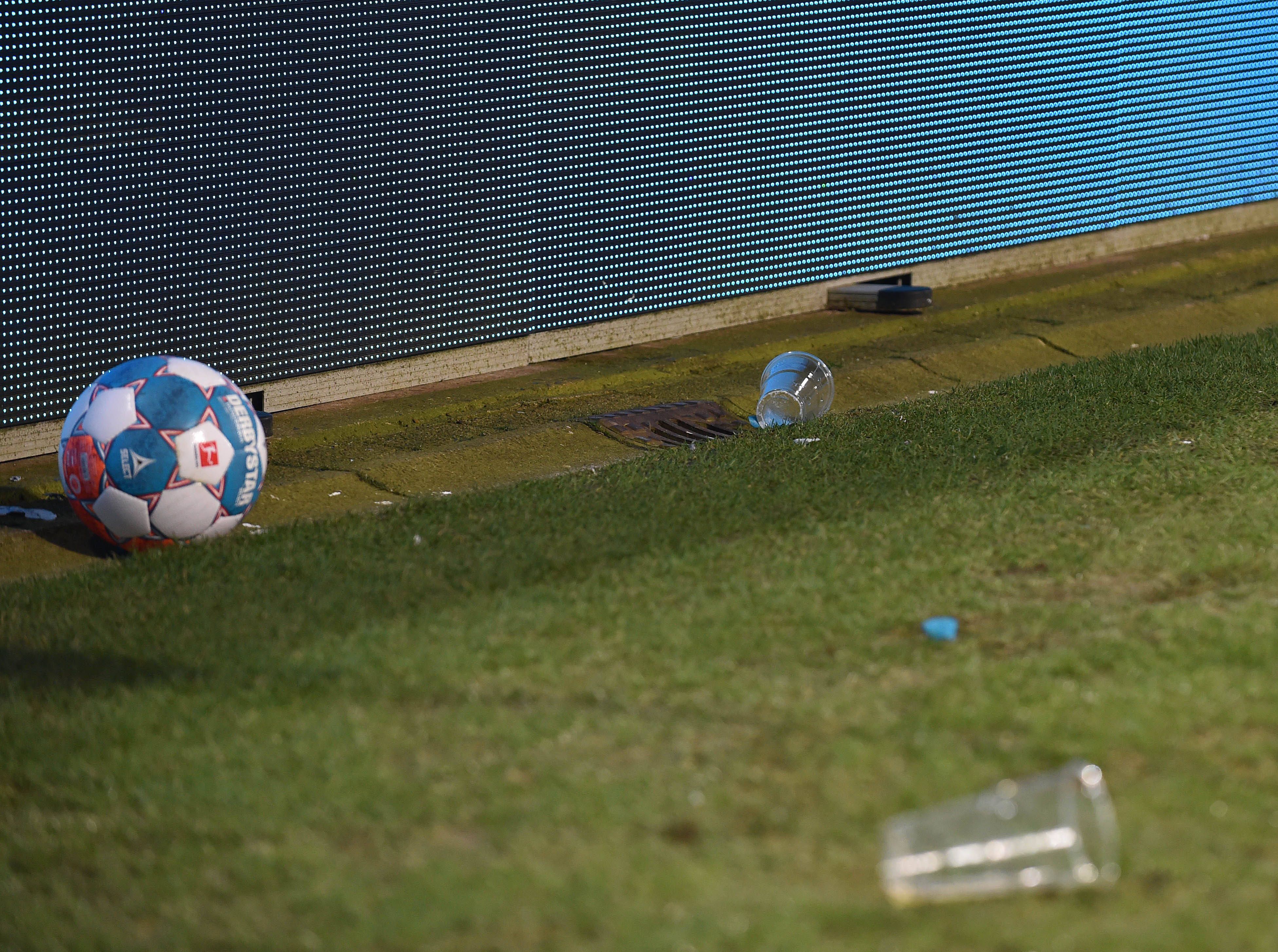 Zwei Bierbecher liegen im Bochumer Ruhrstadion neben einem Ball.