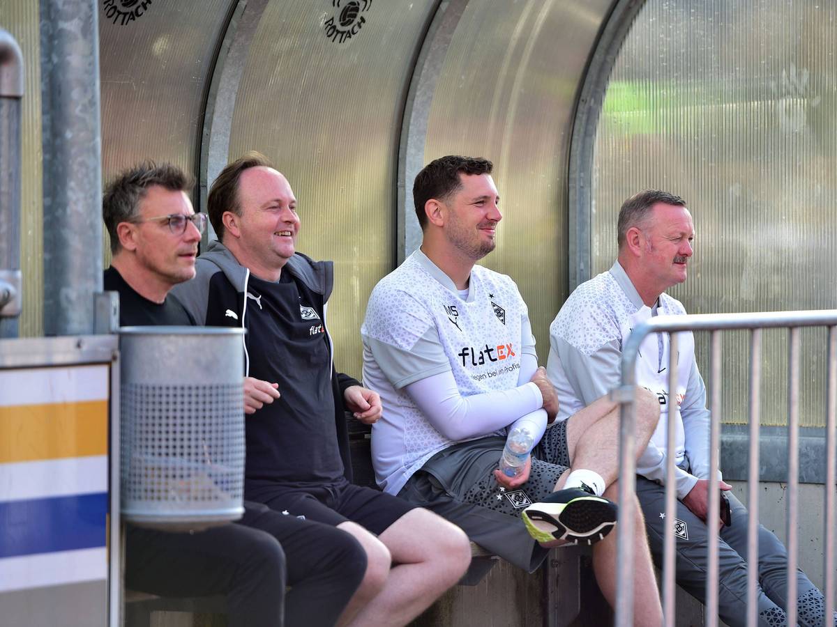 Steffen Korell, Chefscout Mario Vossen, Sportdirektor Nils Schmadtke und Roland Virkus (v.l.n.r.) sitzen im Gladbach-Trainingslager auf einer Ersatzbank.