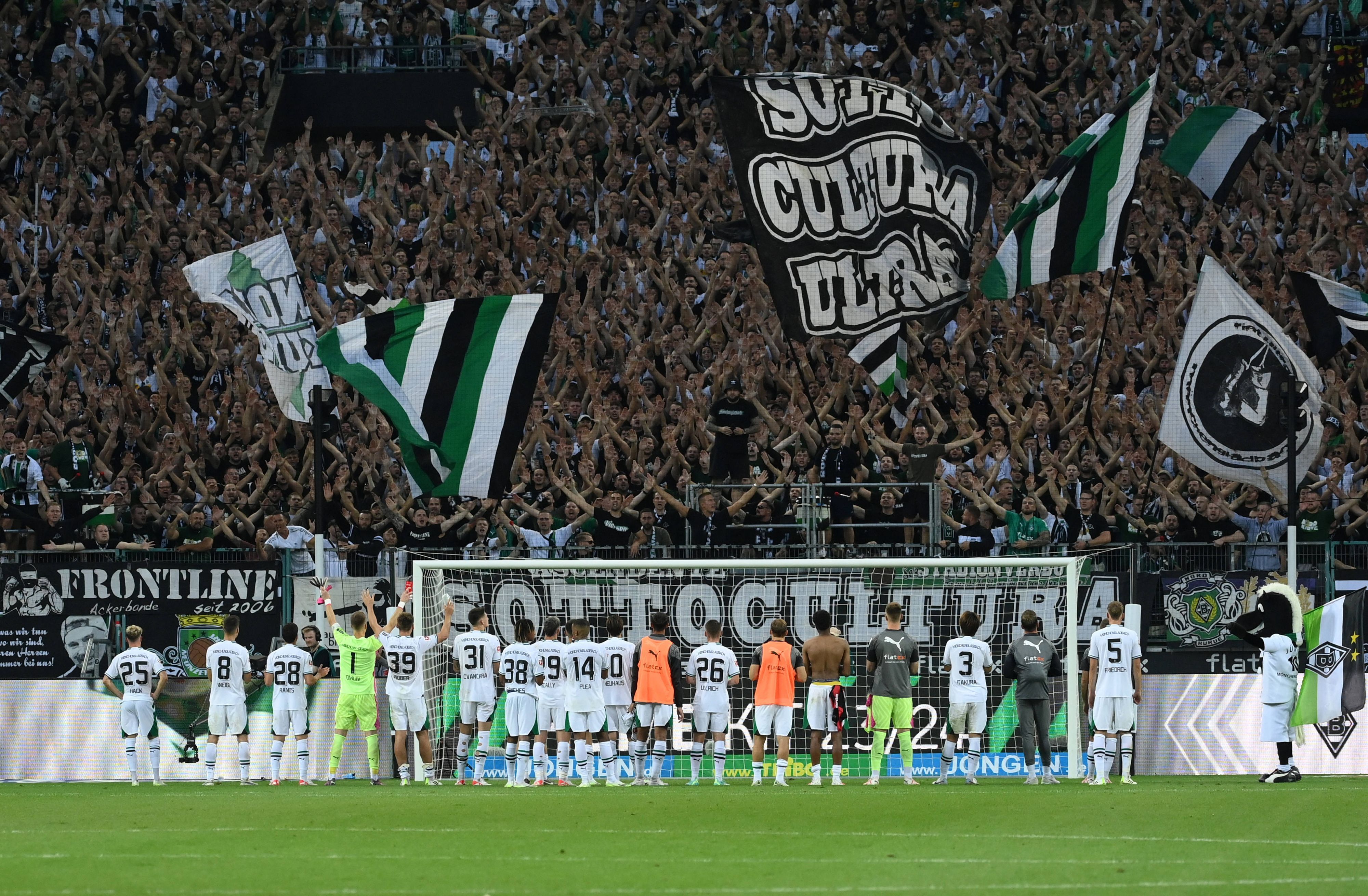 Die Gladbach-Spieler stehen nebeneinander vor ihren Fans in der Nordkurve. Die Fans jubeln und schwenken Fahnen.