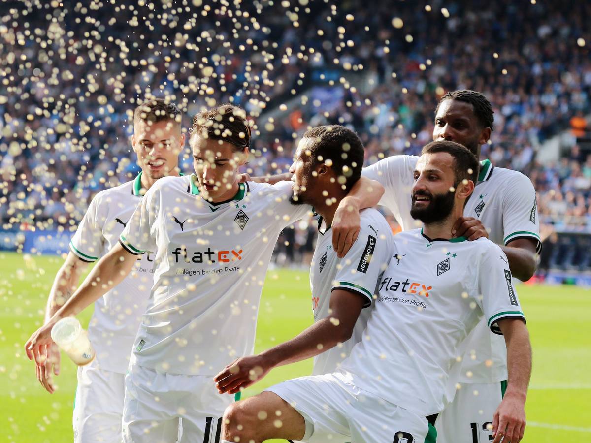 Die Borussia-Spieler jubeln, dabei kommt ein Bierbecher angeflogen.