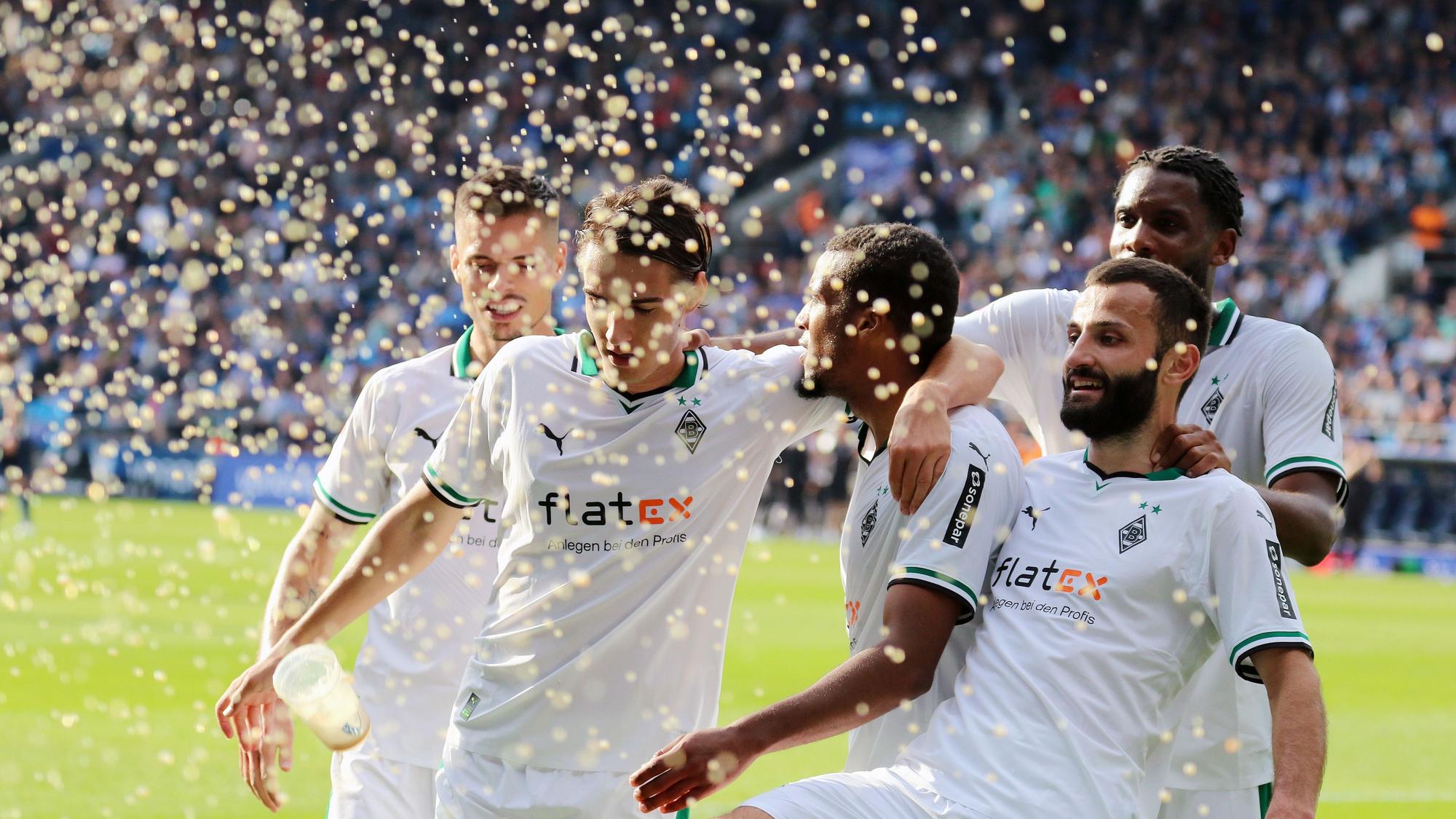 Die Borussia-Spieler jubeln, dabei kommt ein Bierbecher angeflogen.