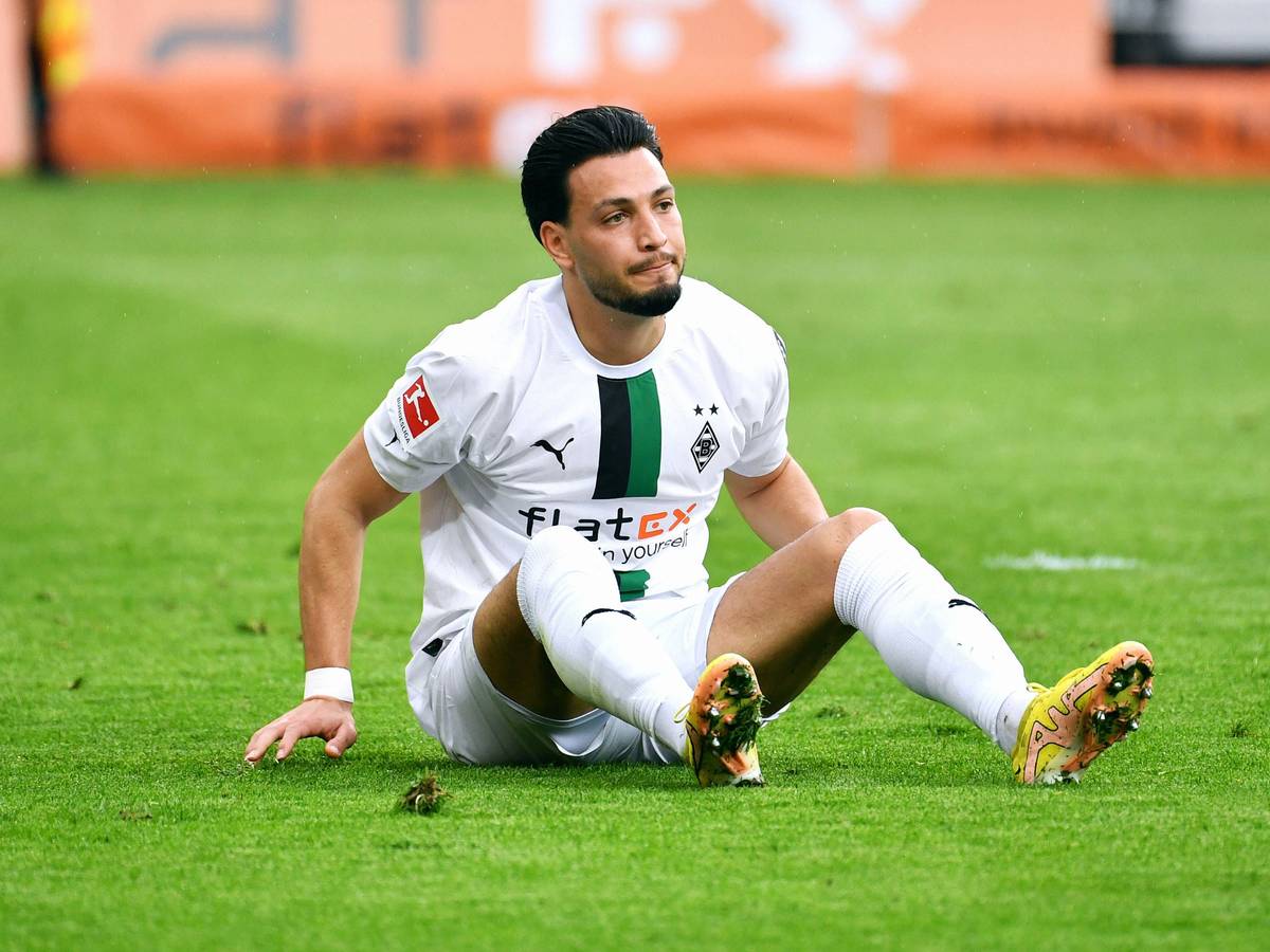 Ramy Bensebaini sitzt auf dem Boden.