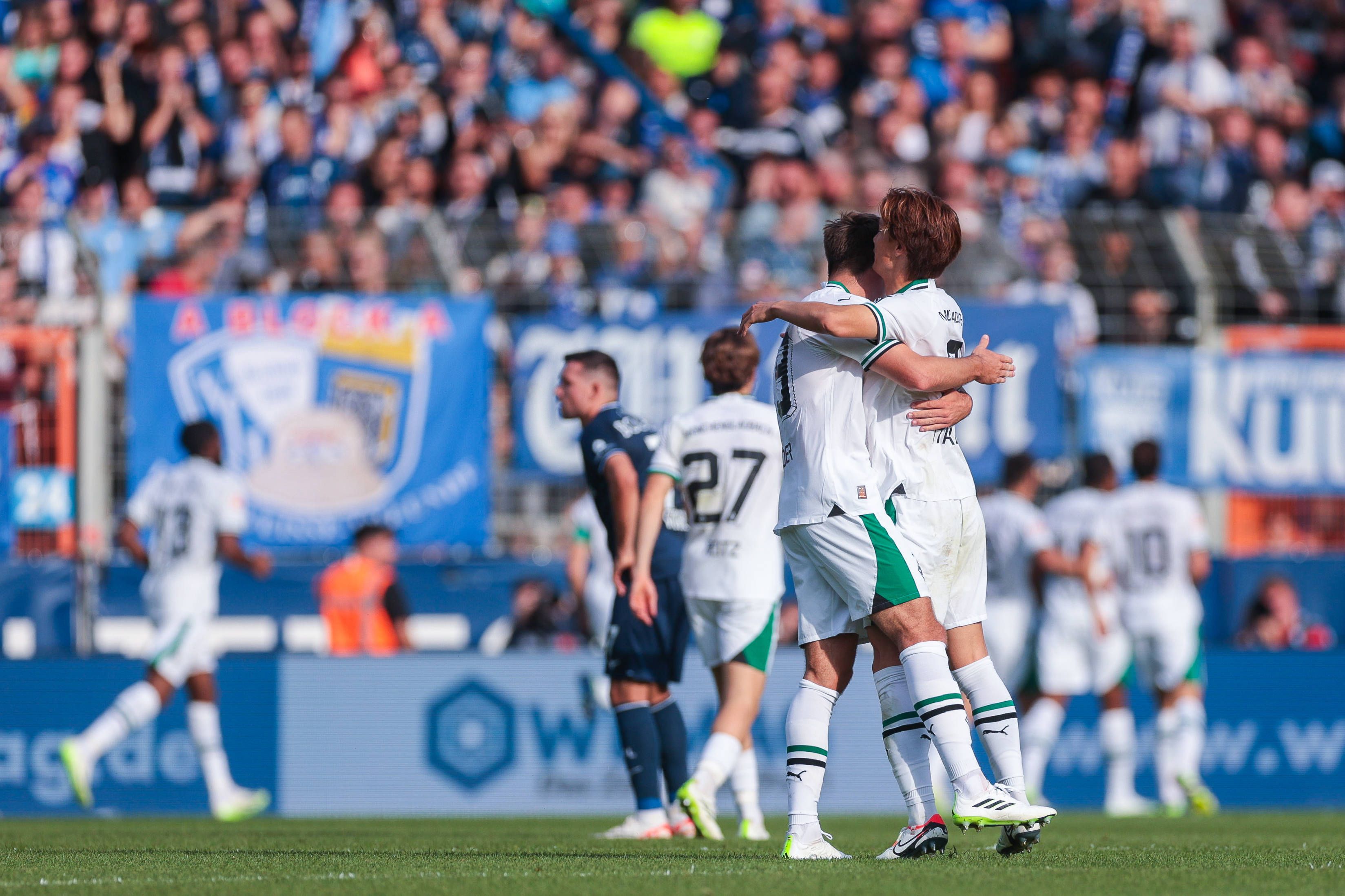 Ko Itakura und Maximilian Wöber liegen sich nach einem Borussia-Tor in den Armen.