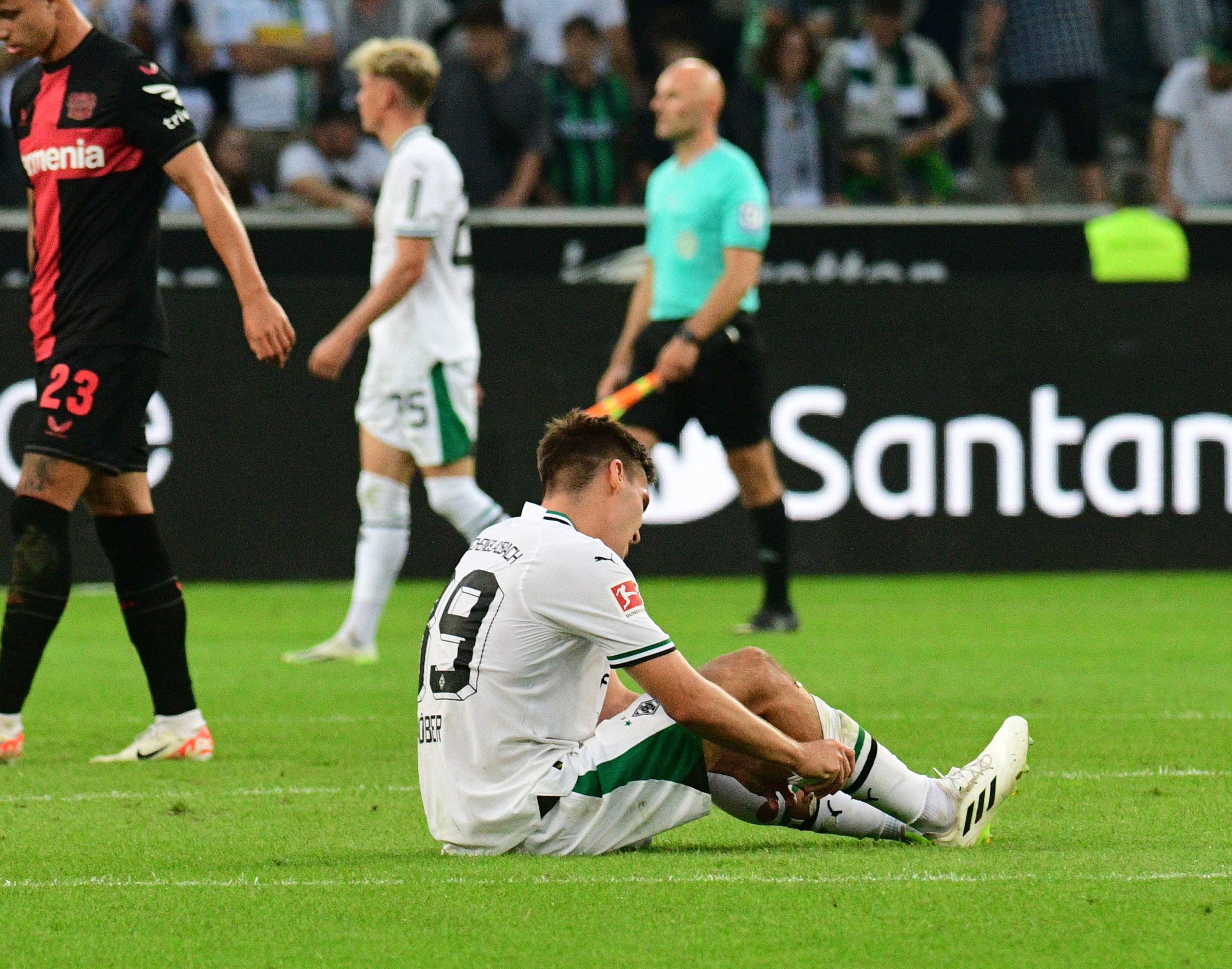 Max Wöber von Borussia Mönchengladbach sitzt enttäuscht am Boden nach dem Spiel gegen Bayer Leverkusen am 26. August 2023.