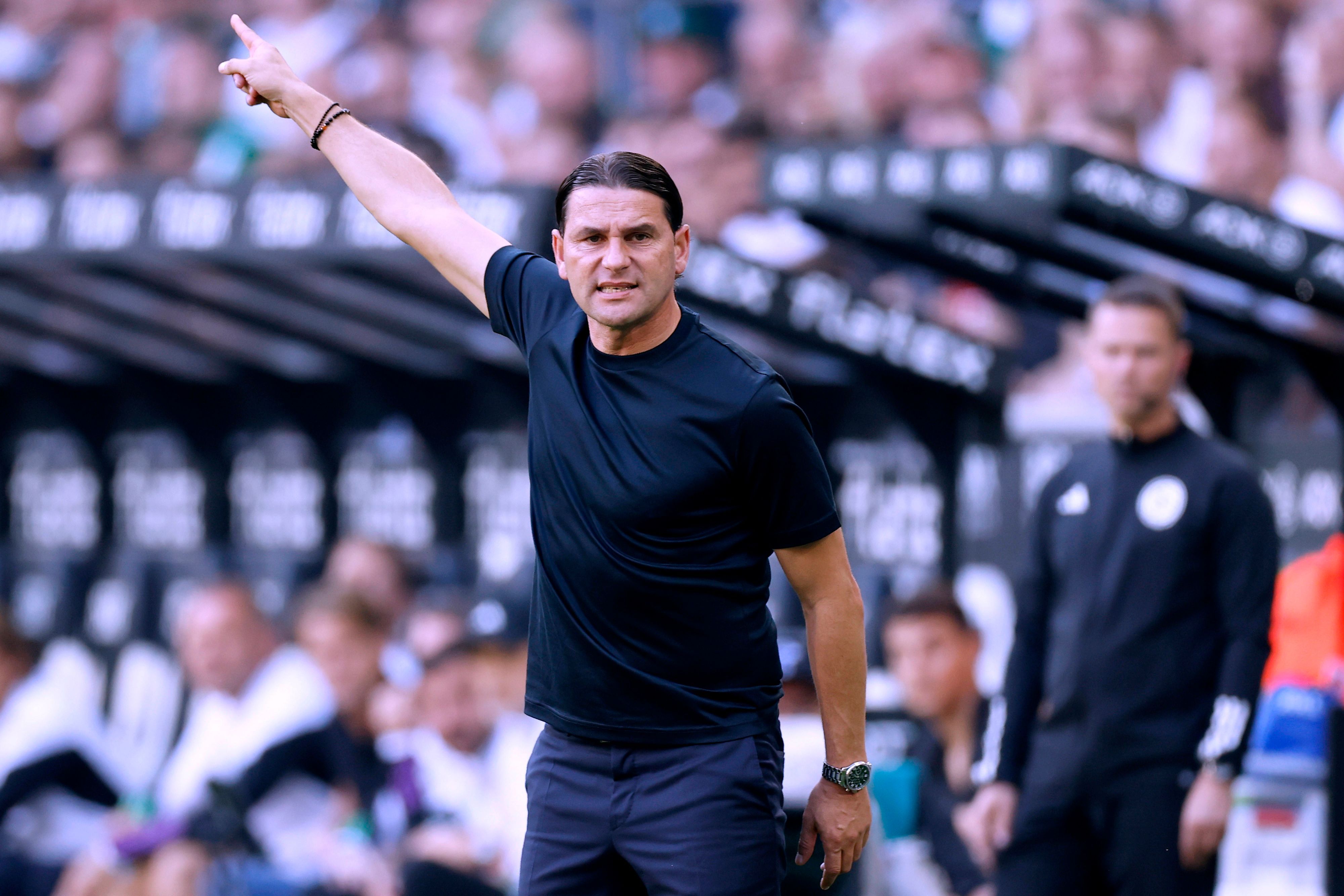 Gerardo Seoane zeigt mit seiner rechten Hand zur Seite.