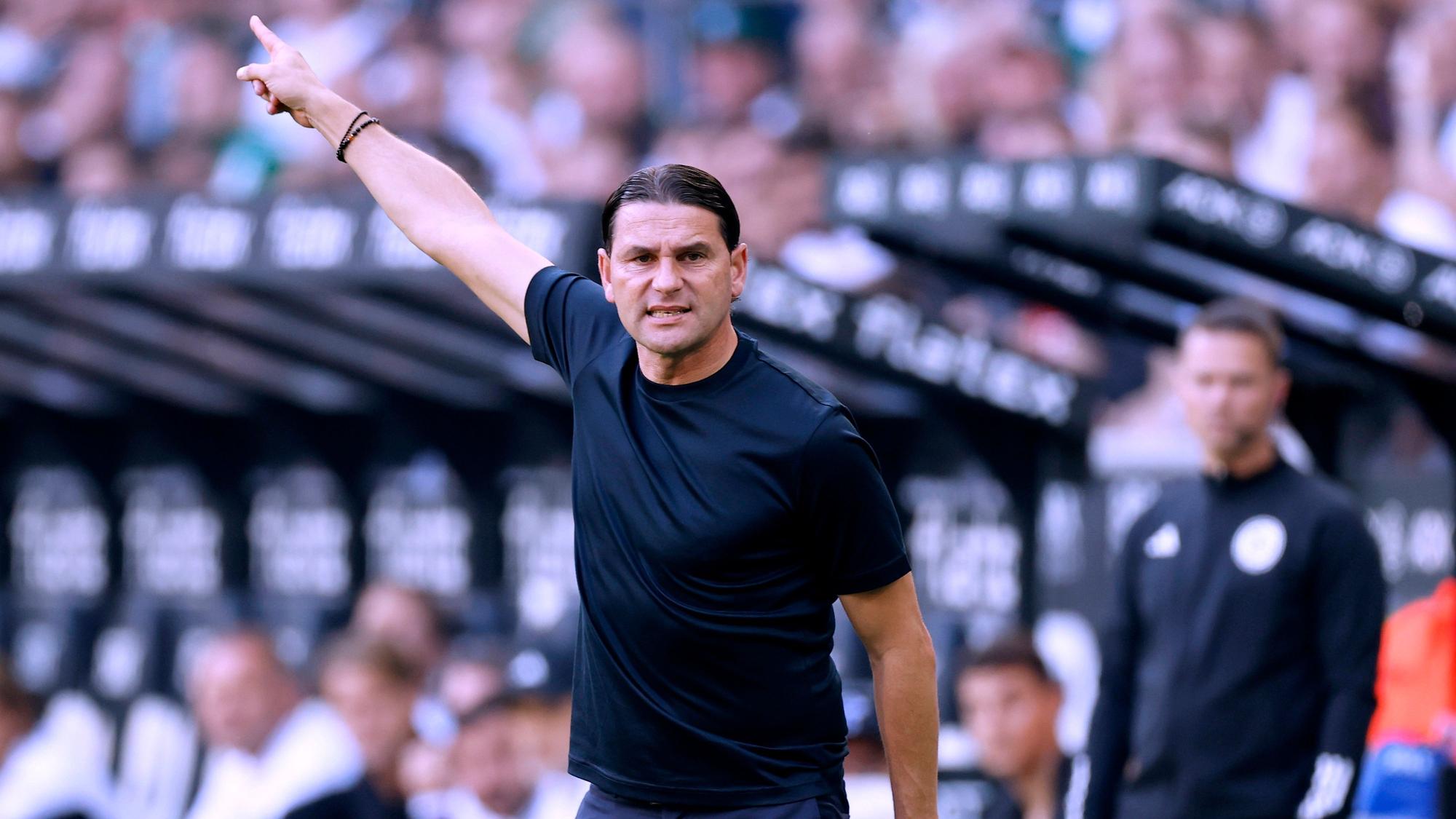 Gerardo Seoane zeigt mit seiner rechten Hand zur Seite.