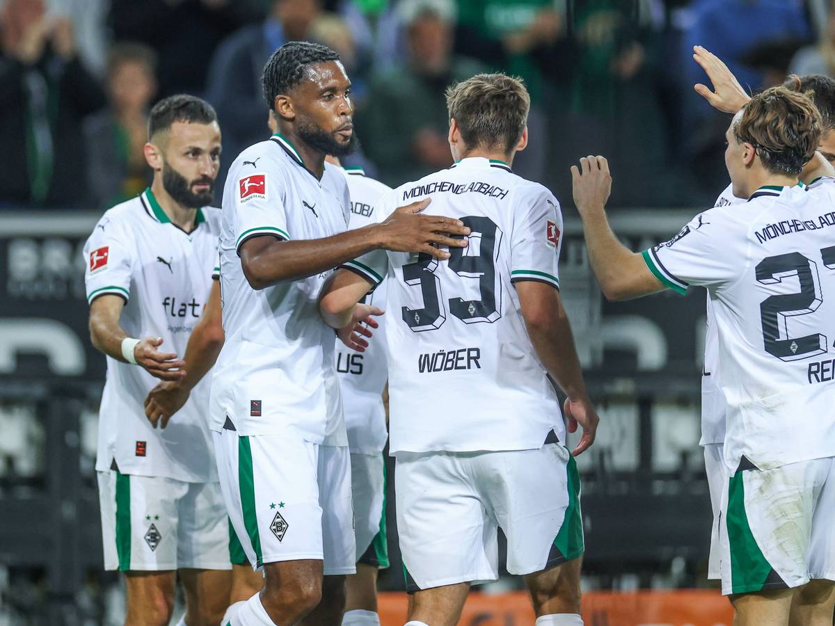 Die Gladbach-Spieler kommen zusammen und bejubeln ein Tor. Im Hintergrund sind Fans.