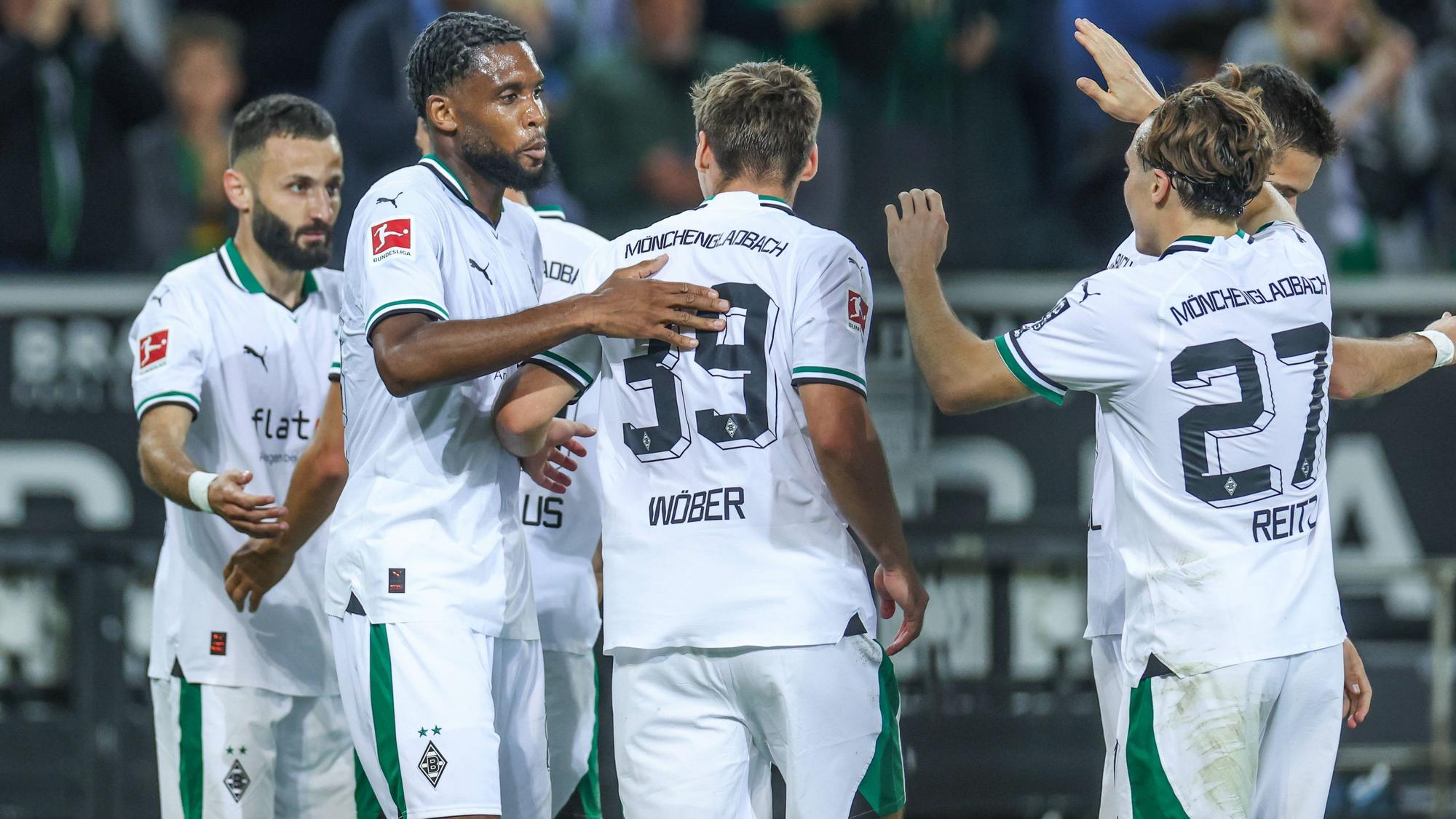 Die Gladbach-Spieler kommen zusammen und bejubeln ein Tor. Im Hintergrund sind Fans.