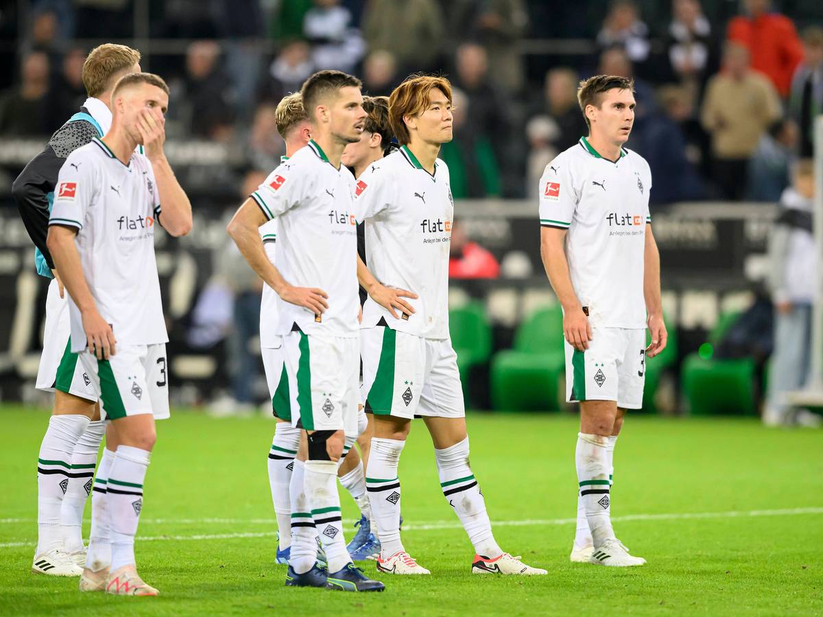 Die Gladbach-Spieler stehen auf dem Rasen und schauen enttäuscht. Im Hintergrund ist die Trainerbank.