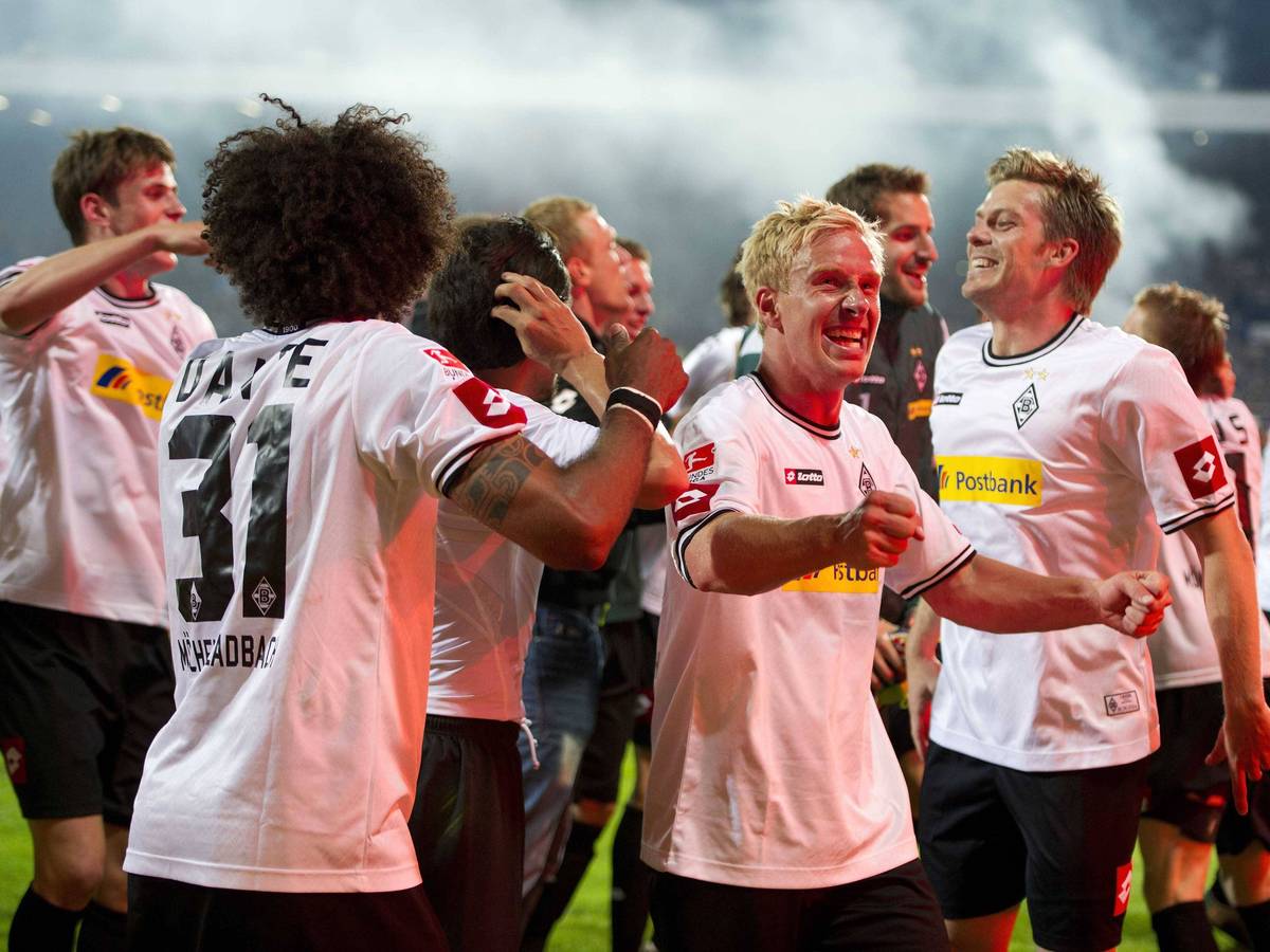 Spieler von Borussia Mönchengladbach jubeln mit den Fans nach dem Klassenerhalt in der Relegation.