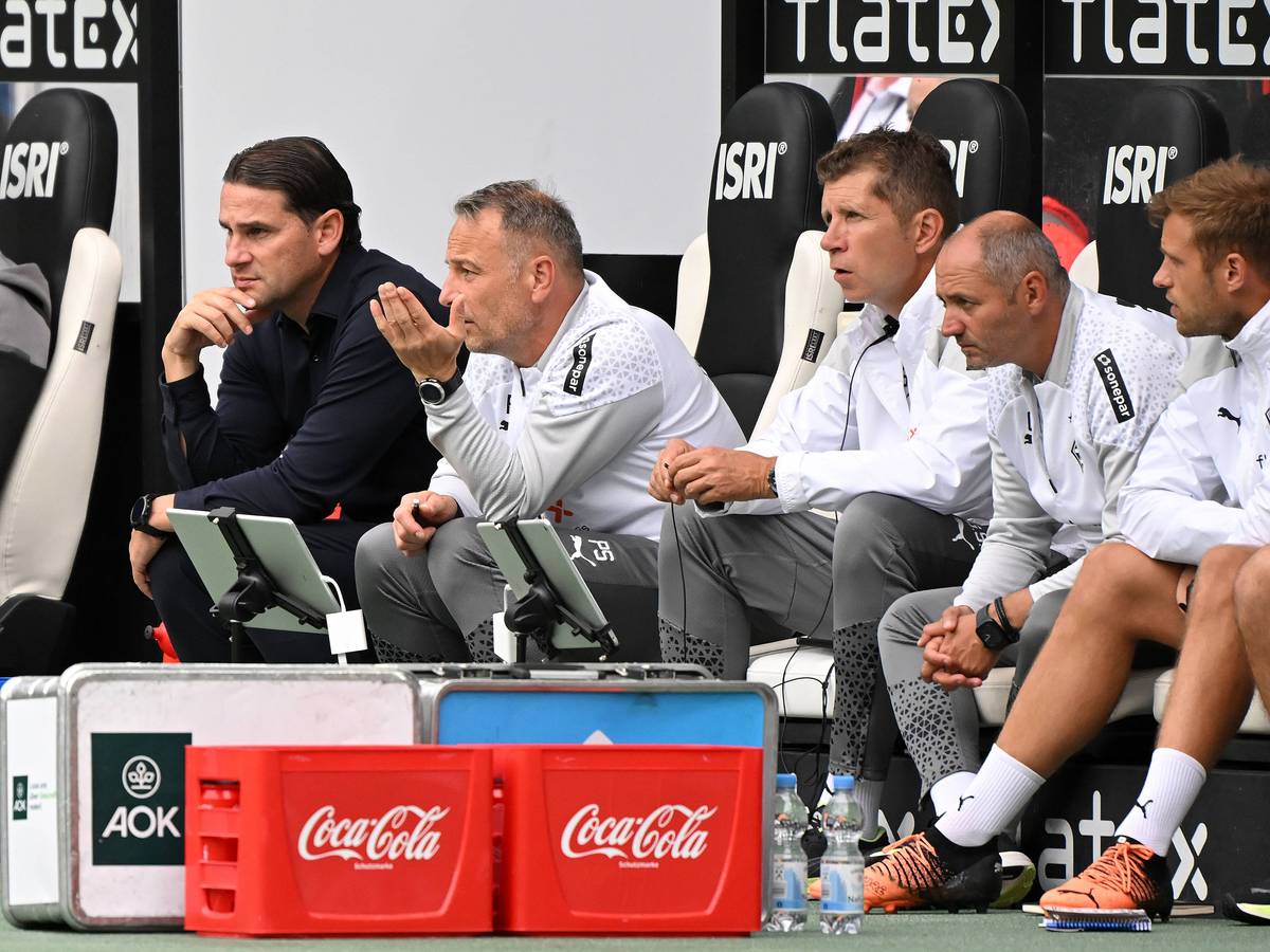 Gerardo Seoane und sein Trainerteam sitzen beim Test-Spiel von Borussia Mönchengladbach gegen den HSC Montpellier auf der Trainerbank und beobachten das Spiel.